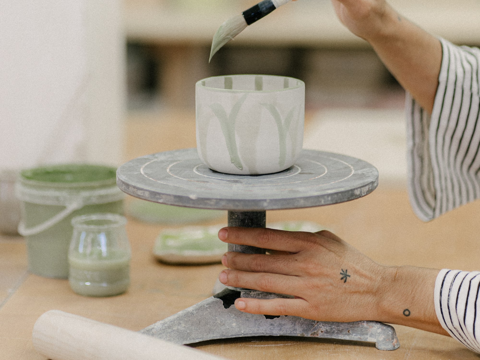 a person painting a cup on a table