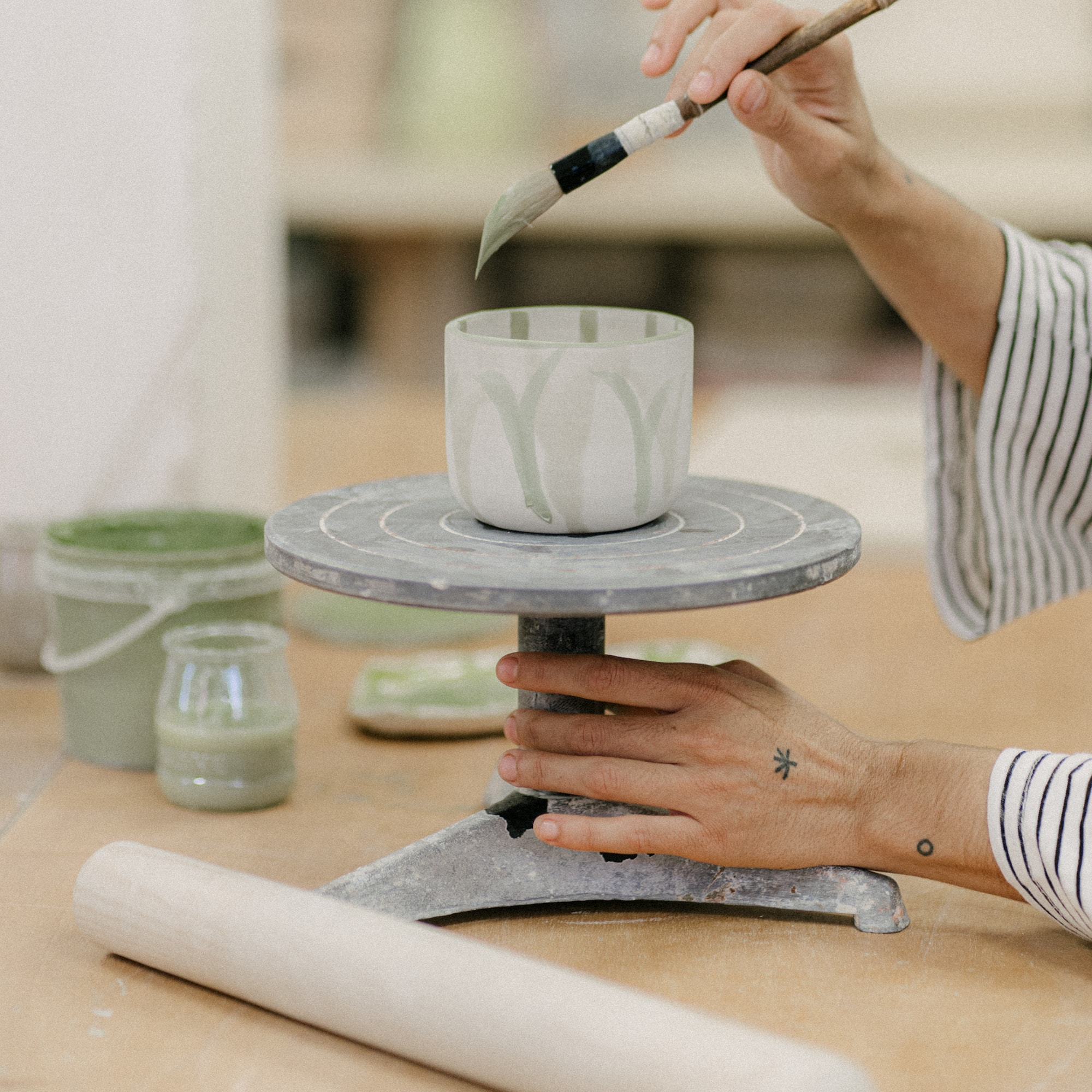 a person painting a cup on a table