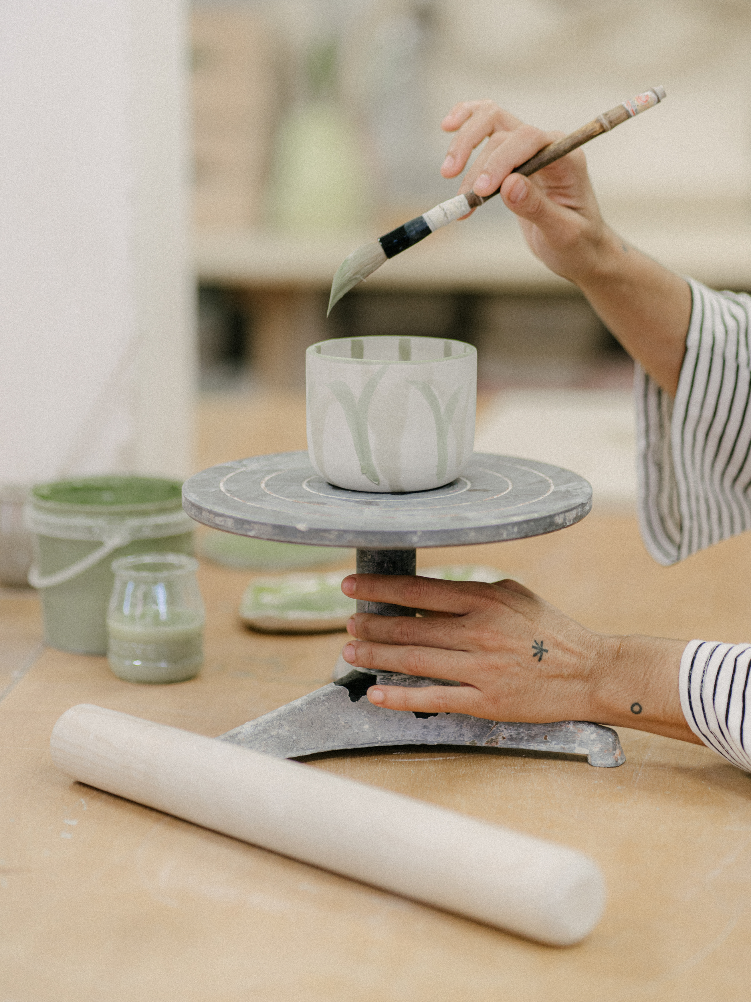 a person painting a cup on a table
