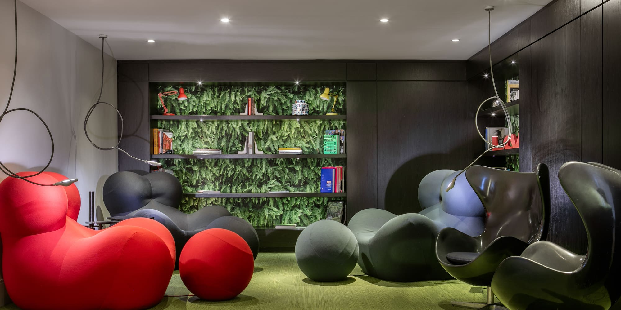 a room with a green wall and a black and red chair