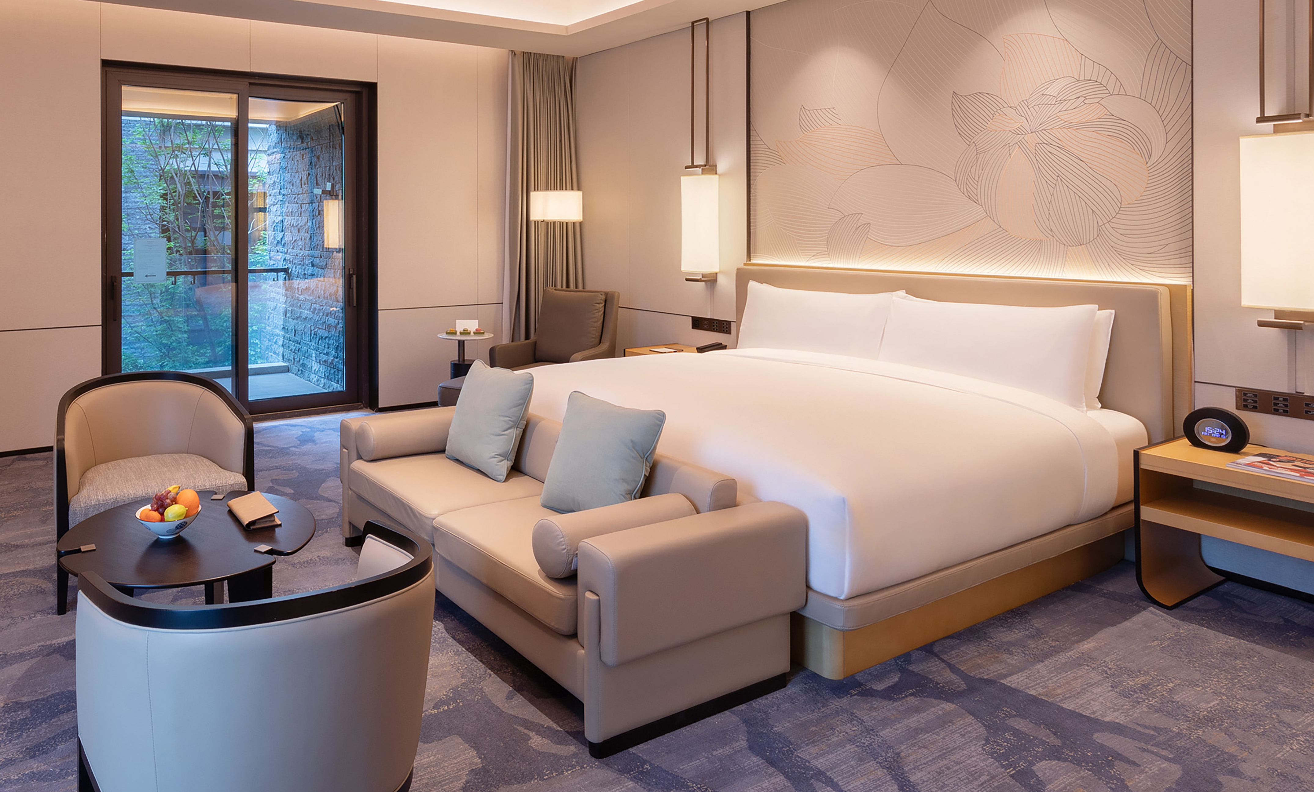 Spacious hotel room featuring a king bed, lounge area, and patio doors.