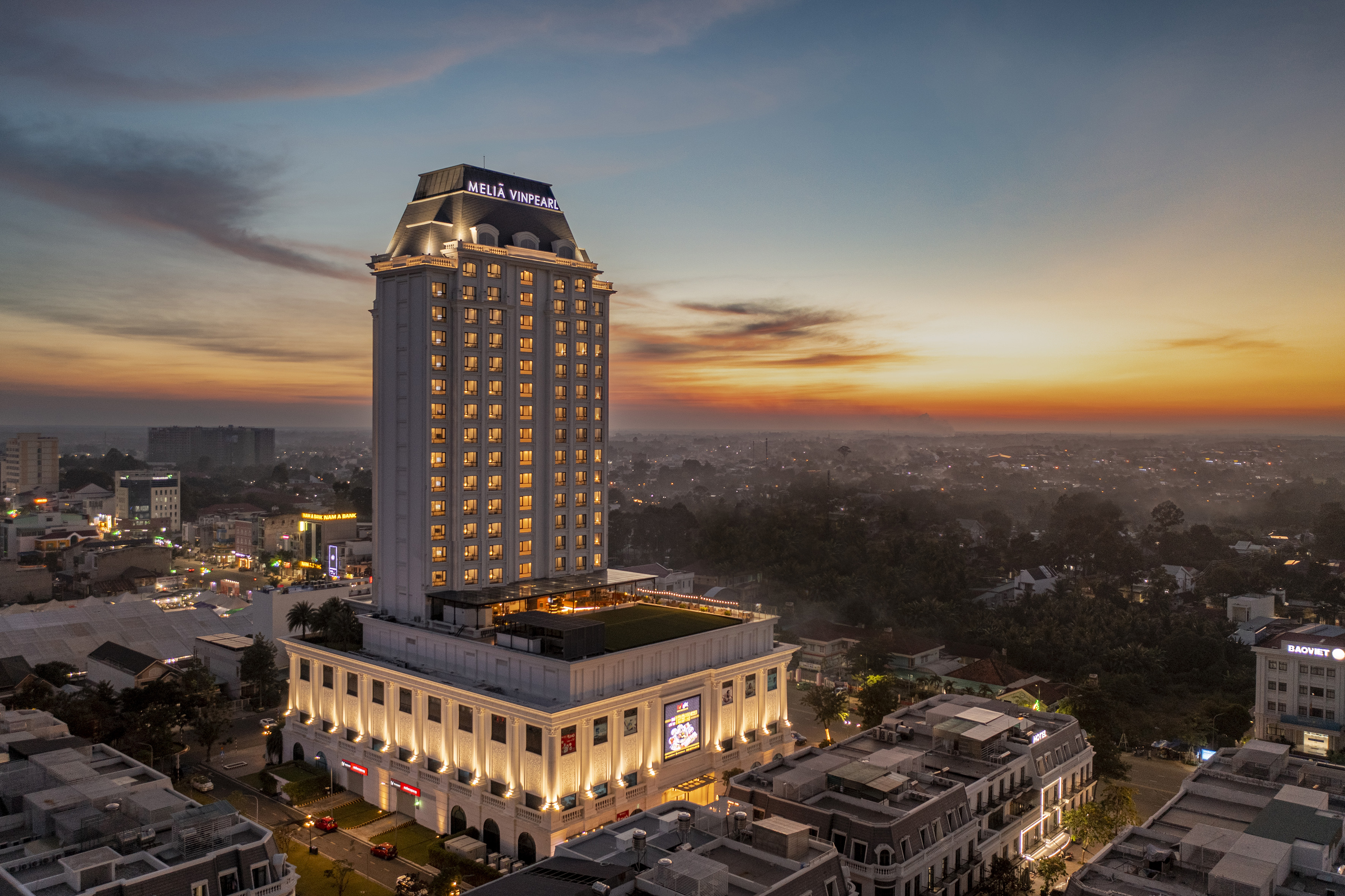 Meliá Vinpearl hotel illuminated at sunset, aerial city view