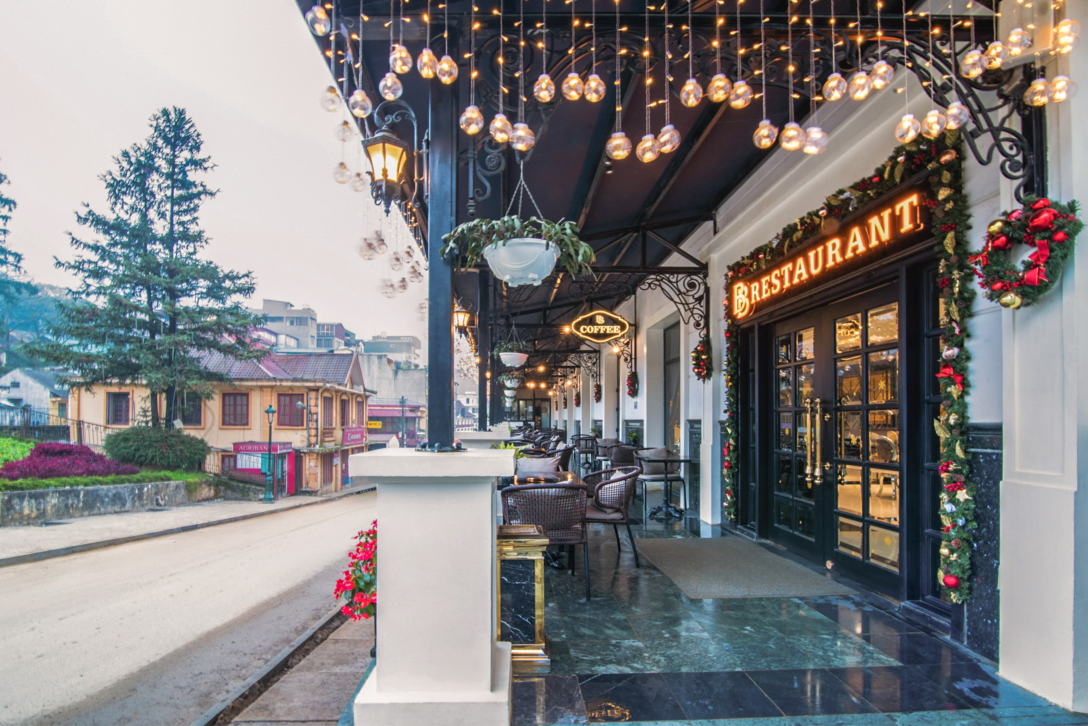 Restaurant entrance with outdoor cafe, string lights, and festive Christmas decor. - Terrace Coffee, Comida ligera - Hotel Sapa Square Affiliated by Meliá, Sapa