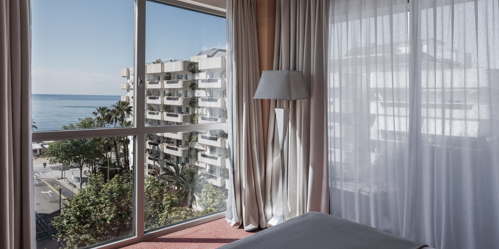 a bedroom with a window overlooking a body of water