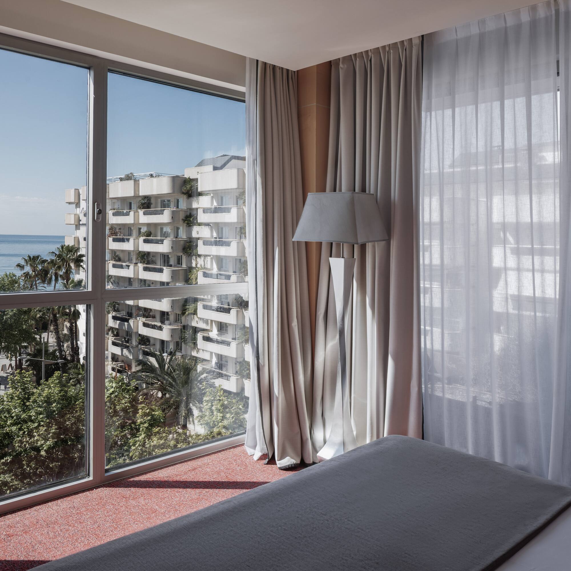 a bedroom with a window overlooking a body of water