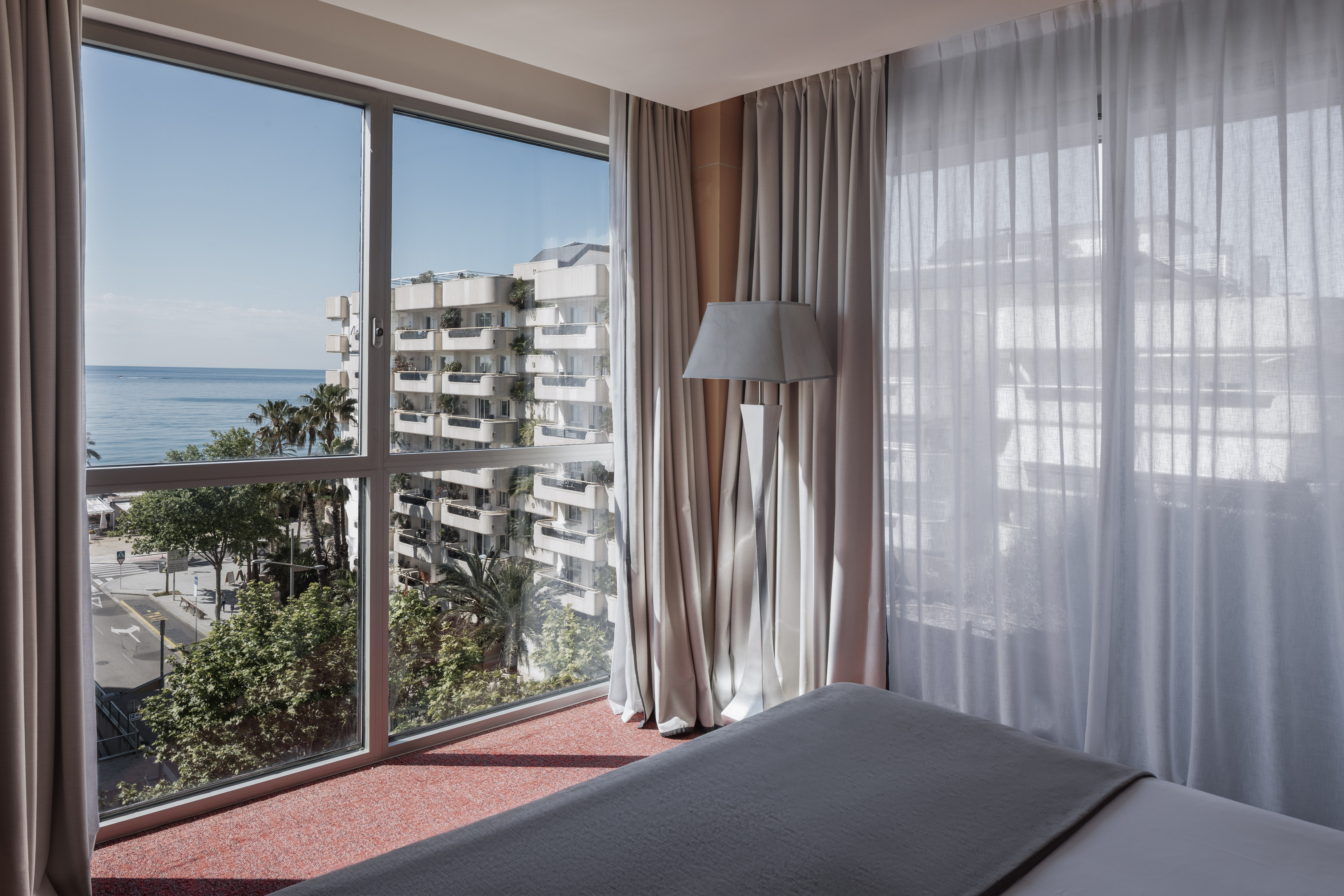 a bedroom with a window overlooking a body of water