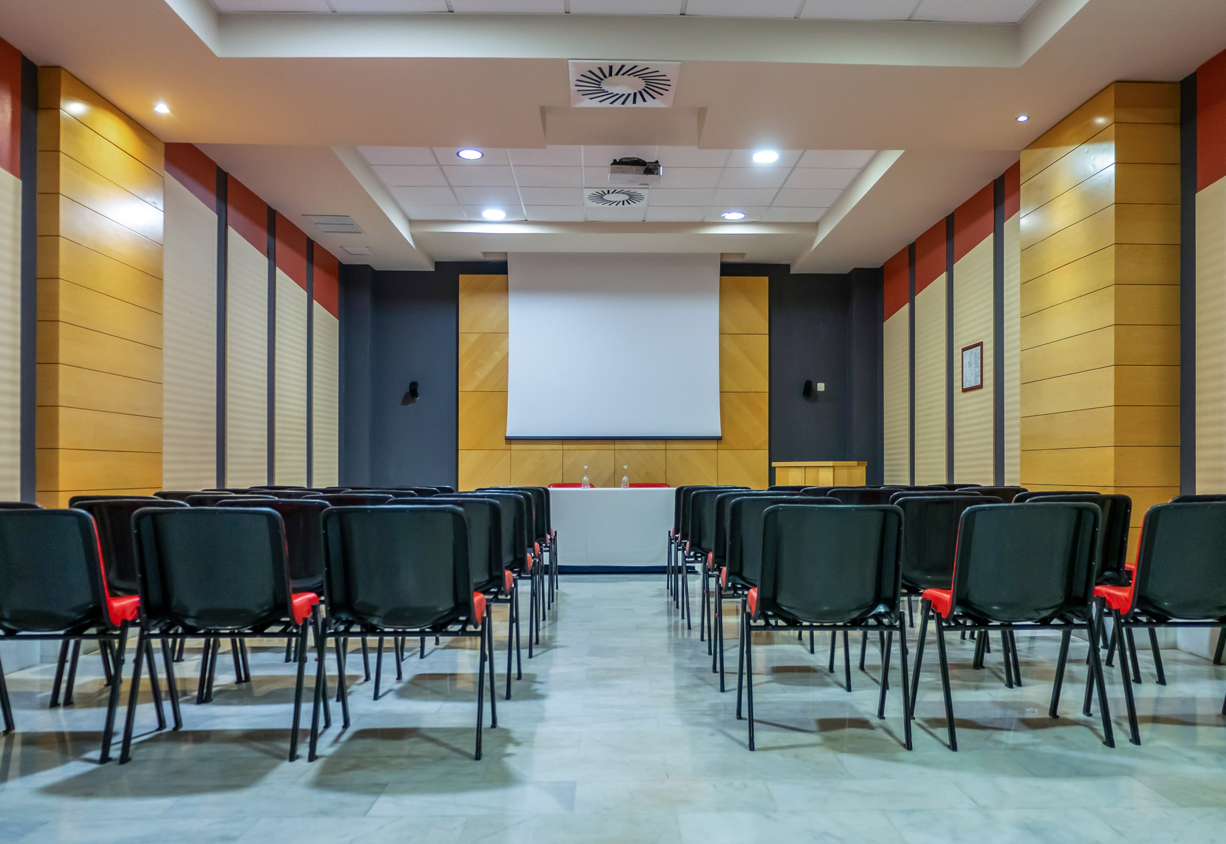a room with chairs and a projector screen