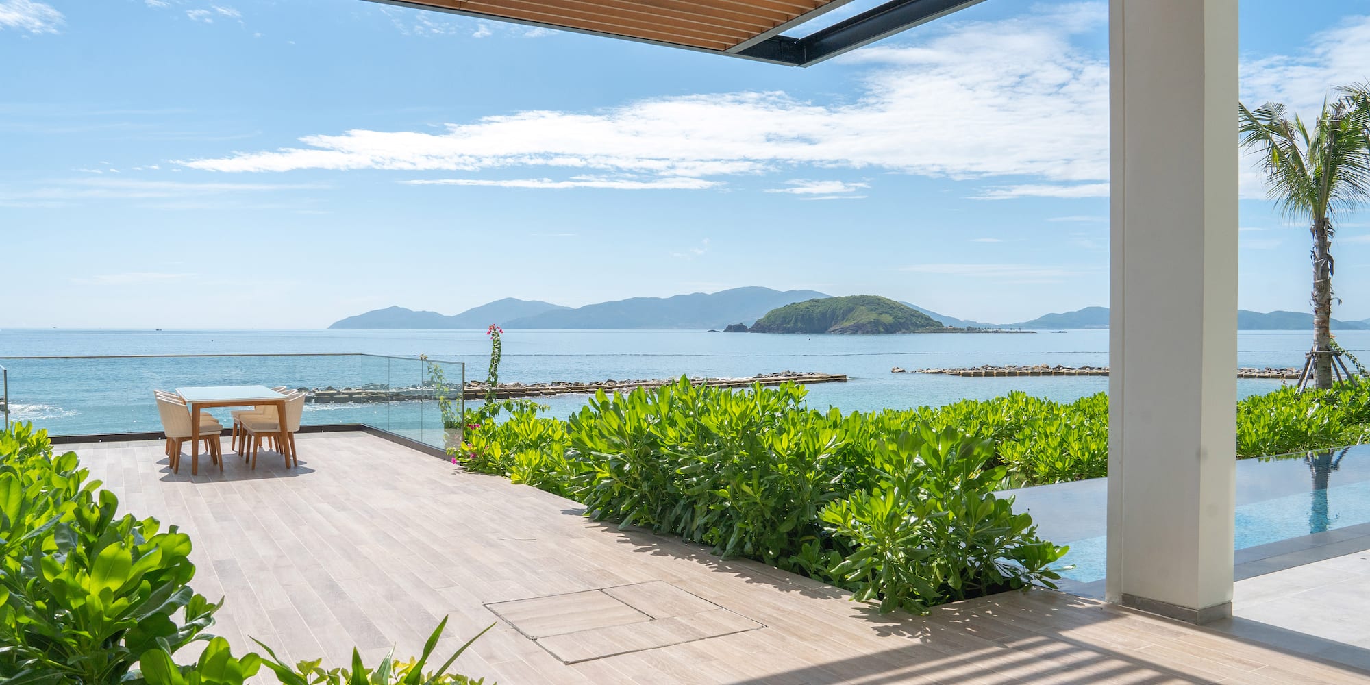 a deck with a table and chairs overlooking the ocean