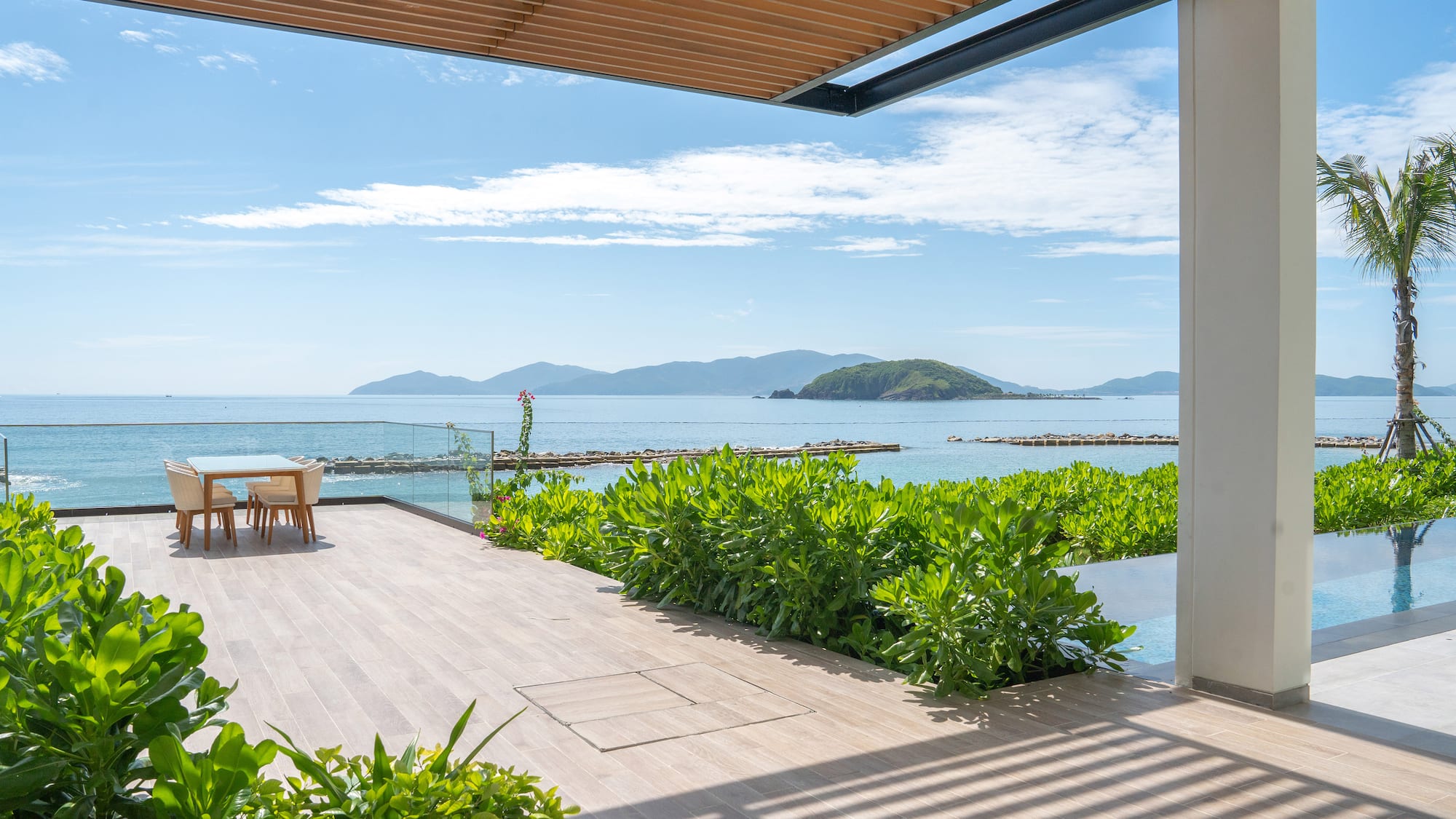 a deck with a table and chairs overlooking the ocean