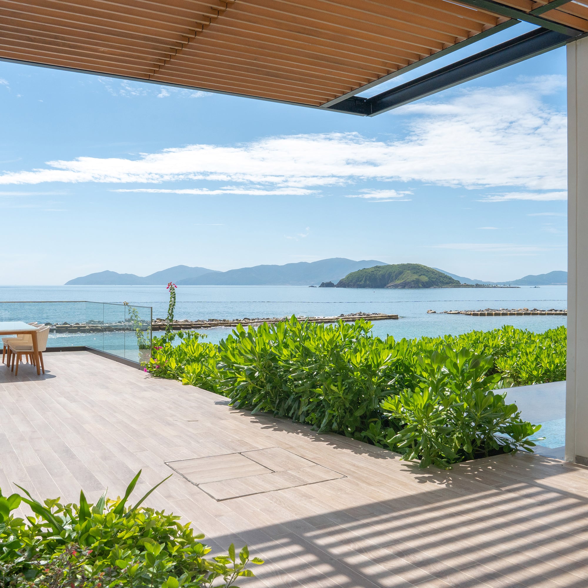 a deck with a table and chairs overlooking the ocean