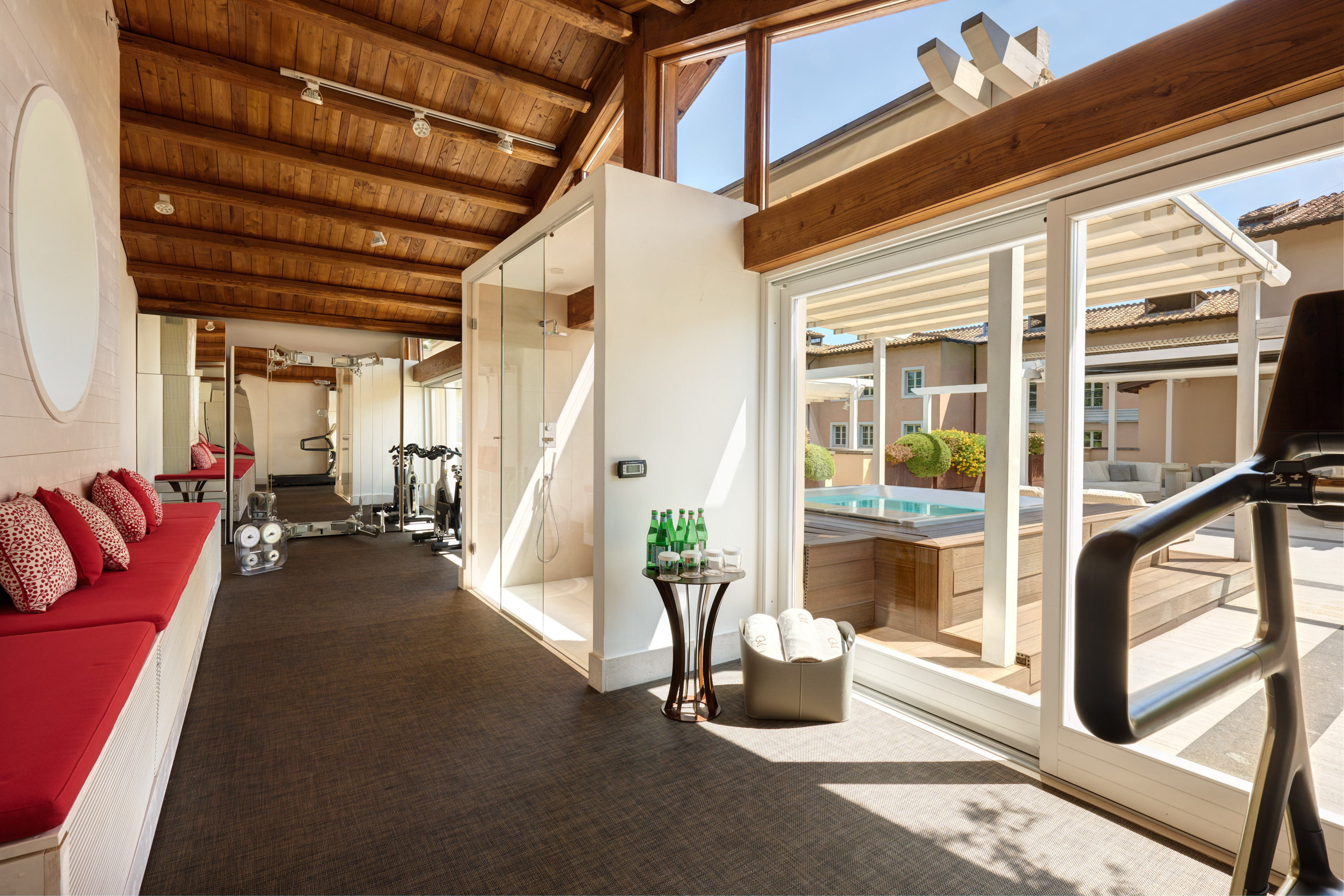 Luxury gym with shower, workout equipment, and outdoor hot tub.