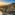 Golden Hour aerial of Marbella coast, luxury homes, mountains, and sea.