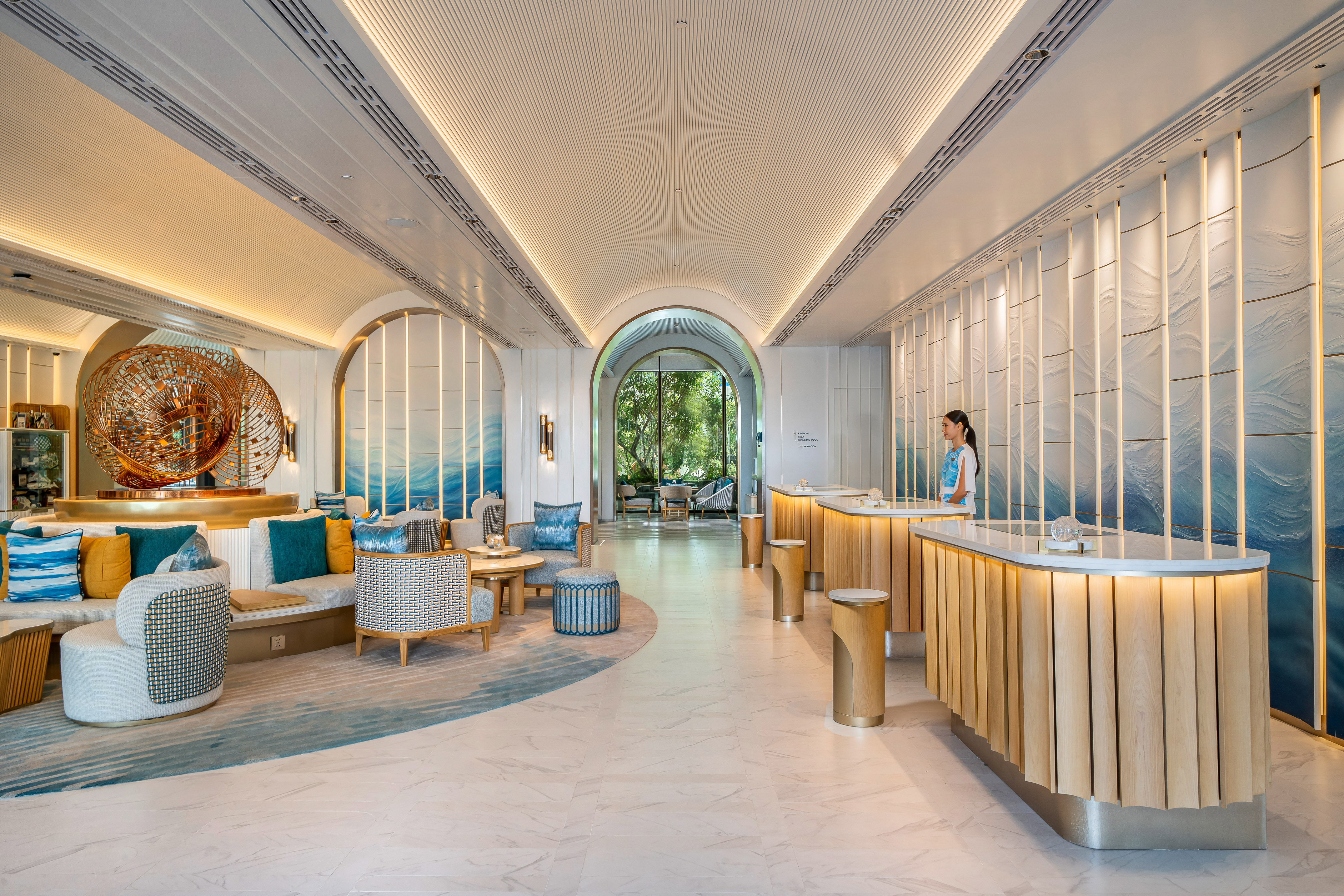 Resort lobby with modern wood reception, blue wave wall art, and lounge area.