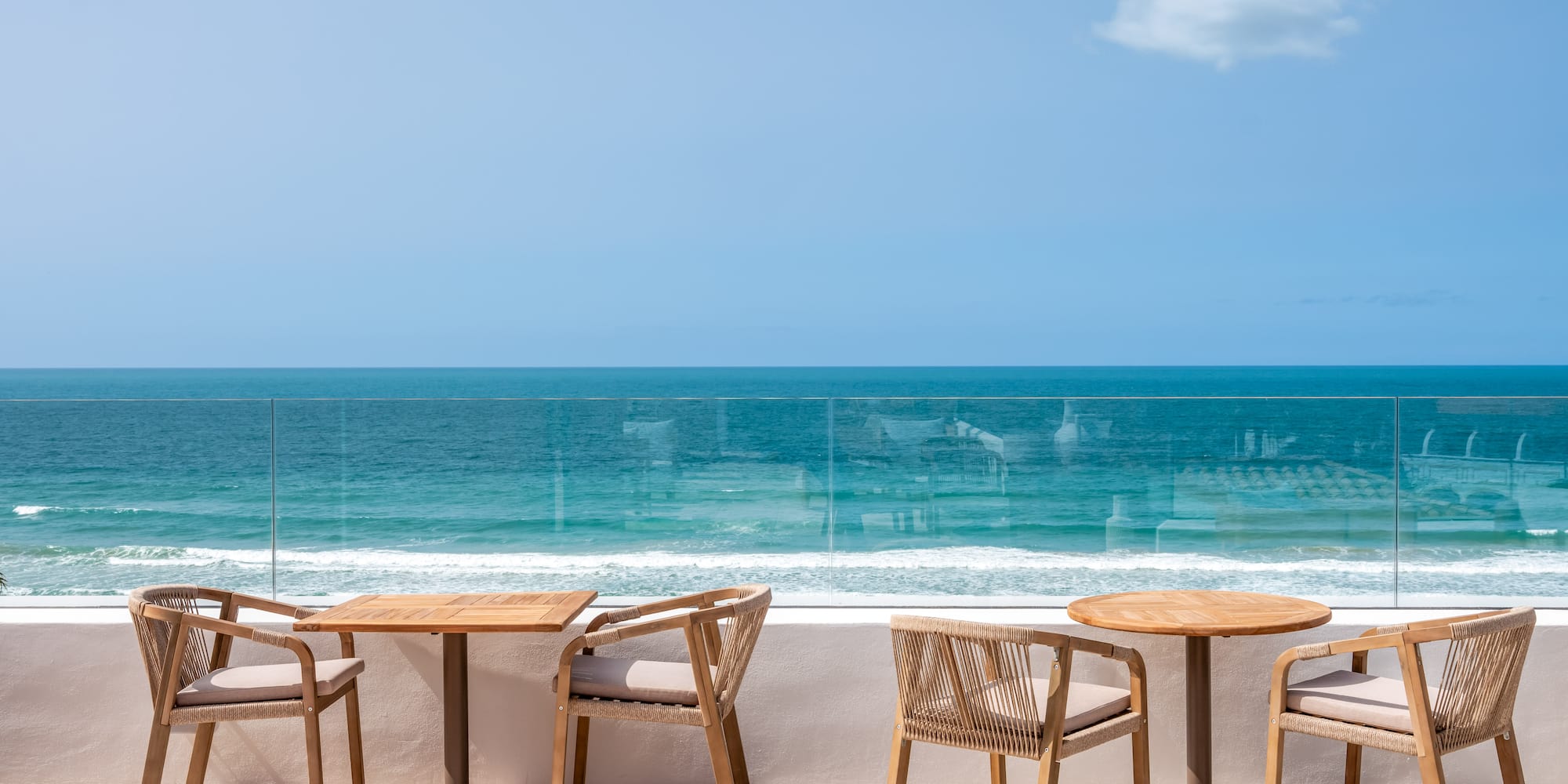 a table and chairs on a patio overlooking the ocean