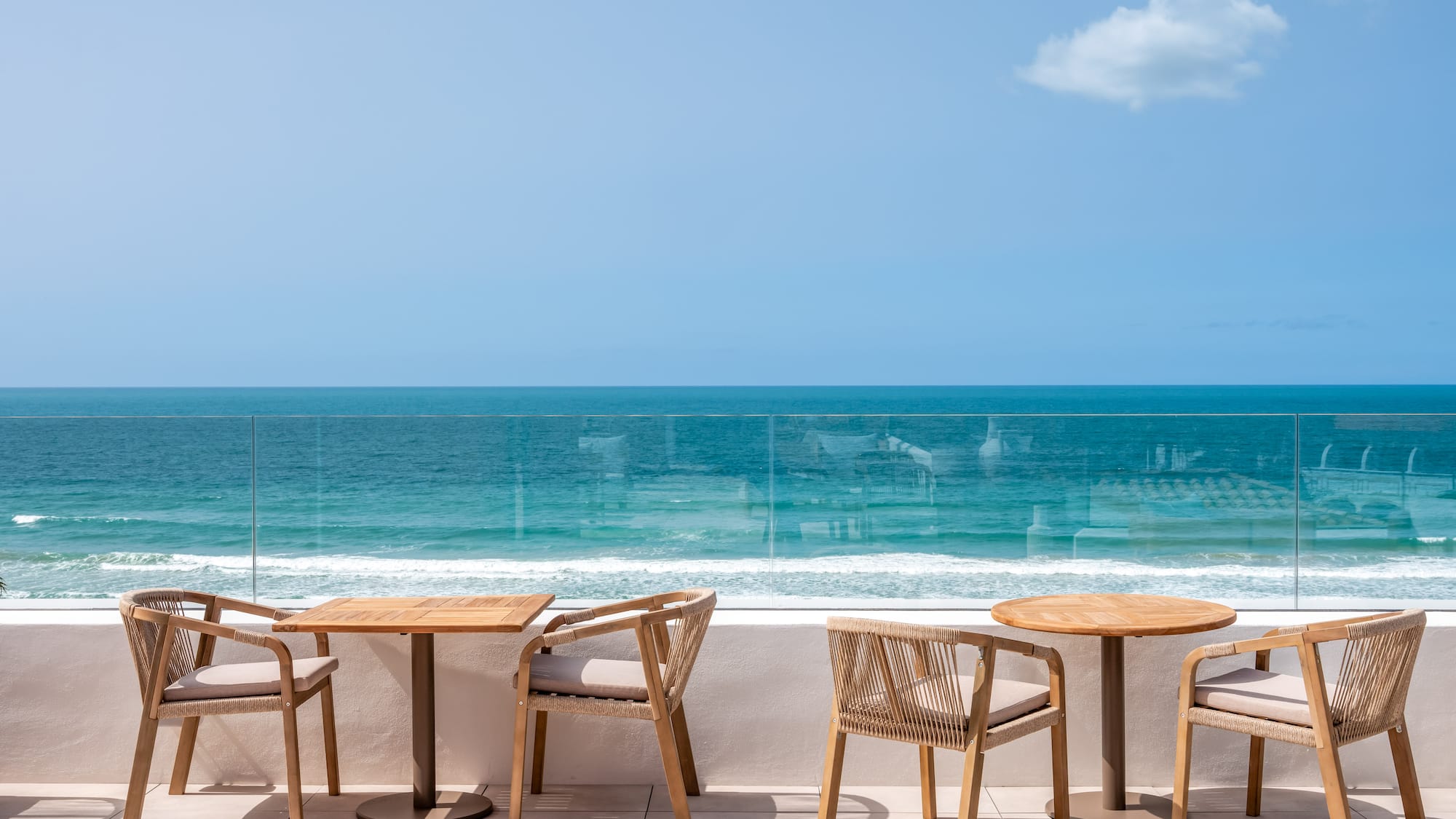a table and chairs on a patio overlooking the ocean