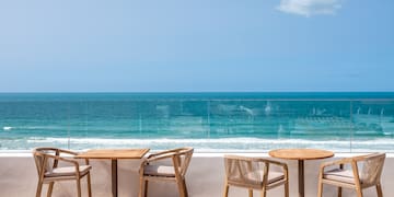 a table and chairs on a patio overlooking the ocean