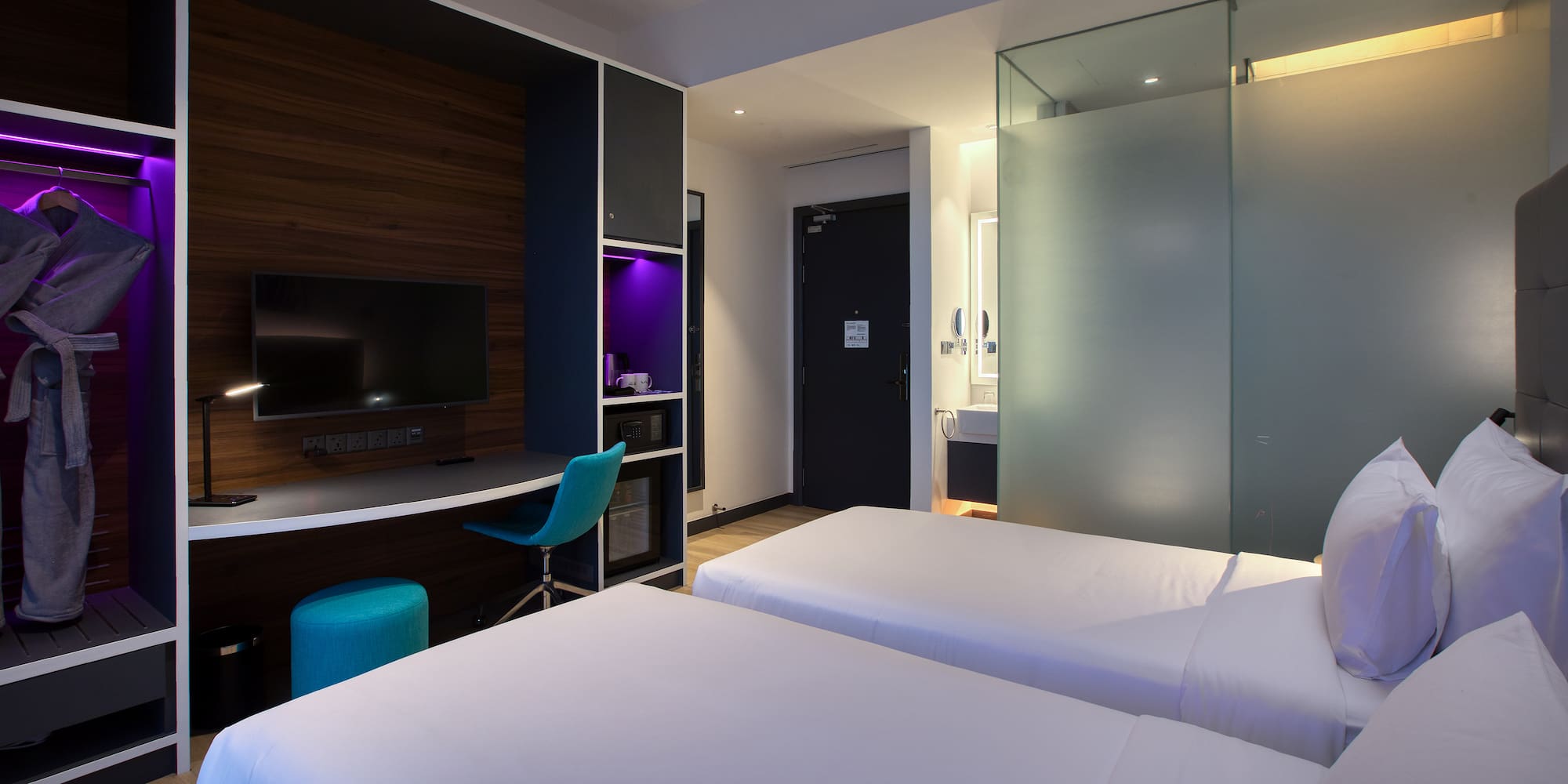 a room with two beds and a desk