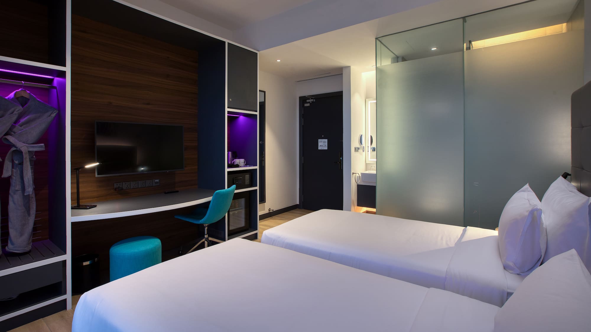 a room with two beds and a desk