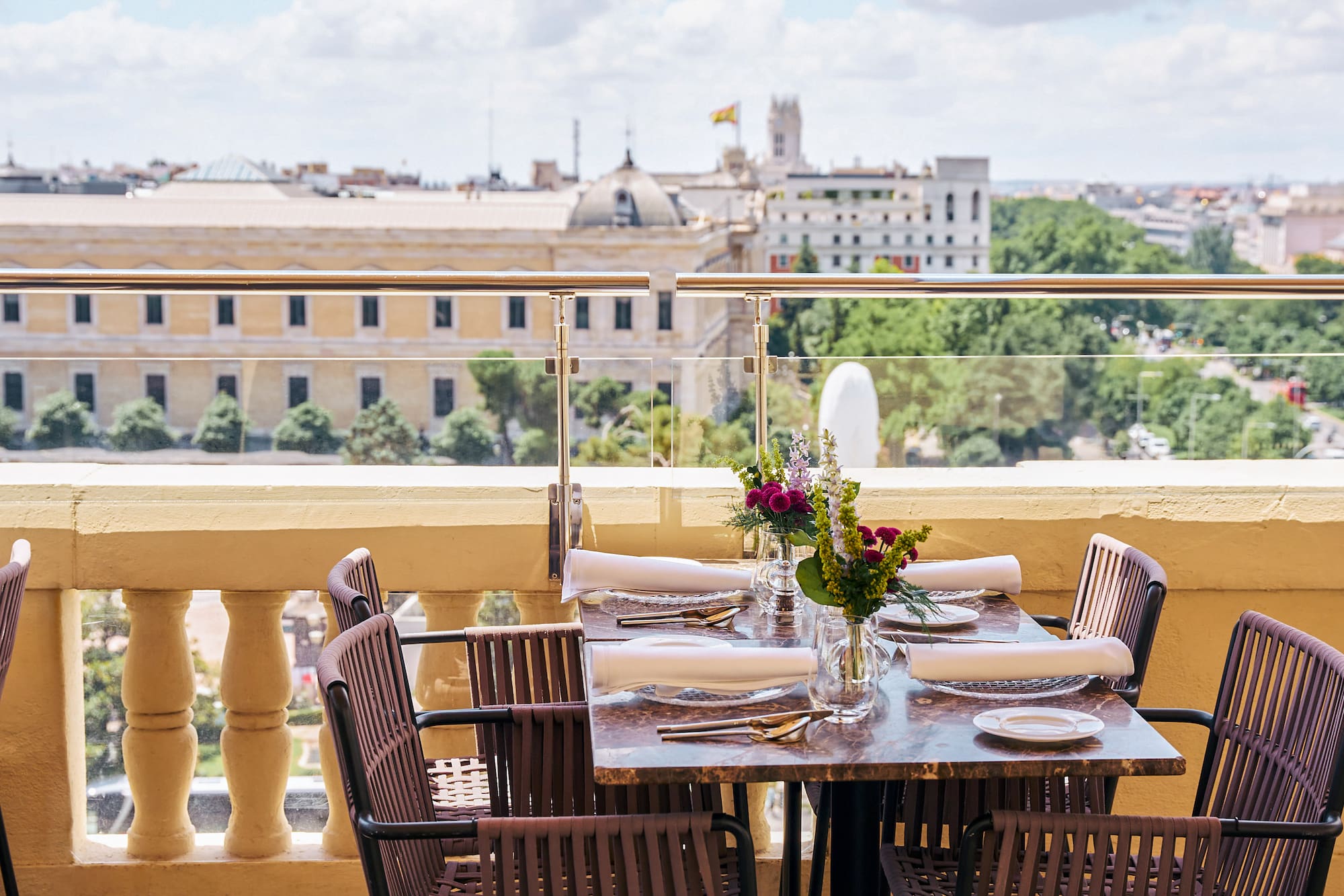 Rooftop dining table with flowers overlooking the Madrid cityscape.