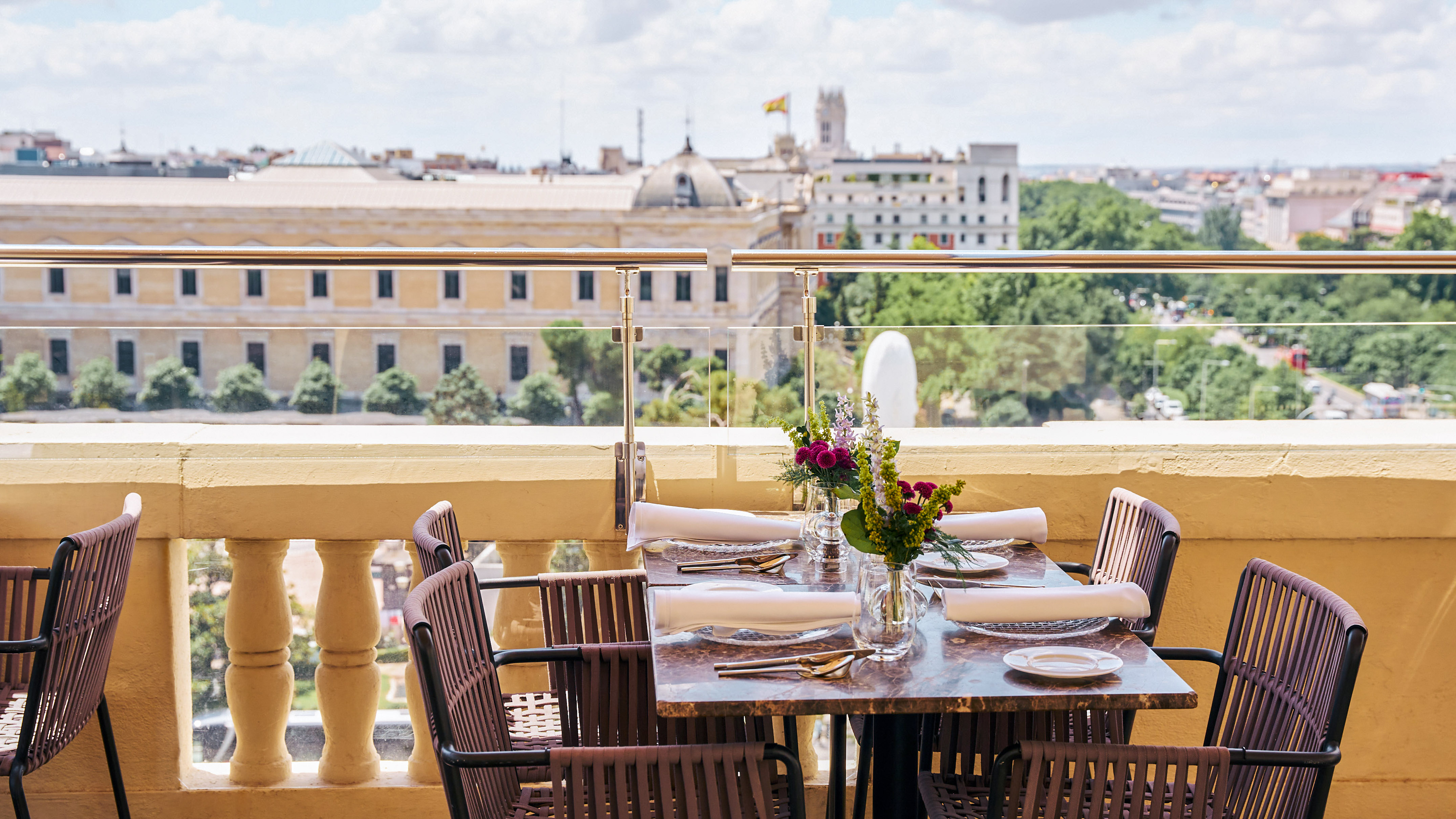 Rooftop dining table with flowers overlooking the Madrid cityscape.