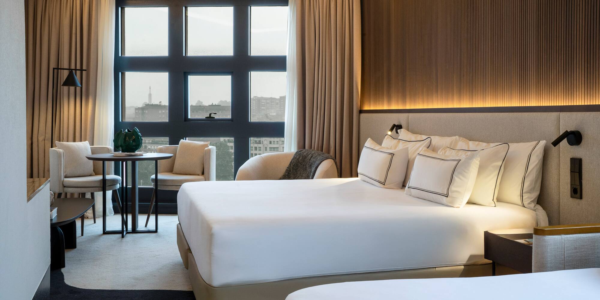 a room with a bed and chairs