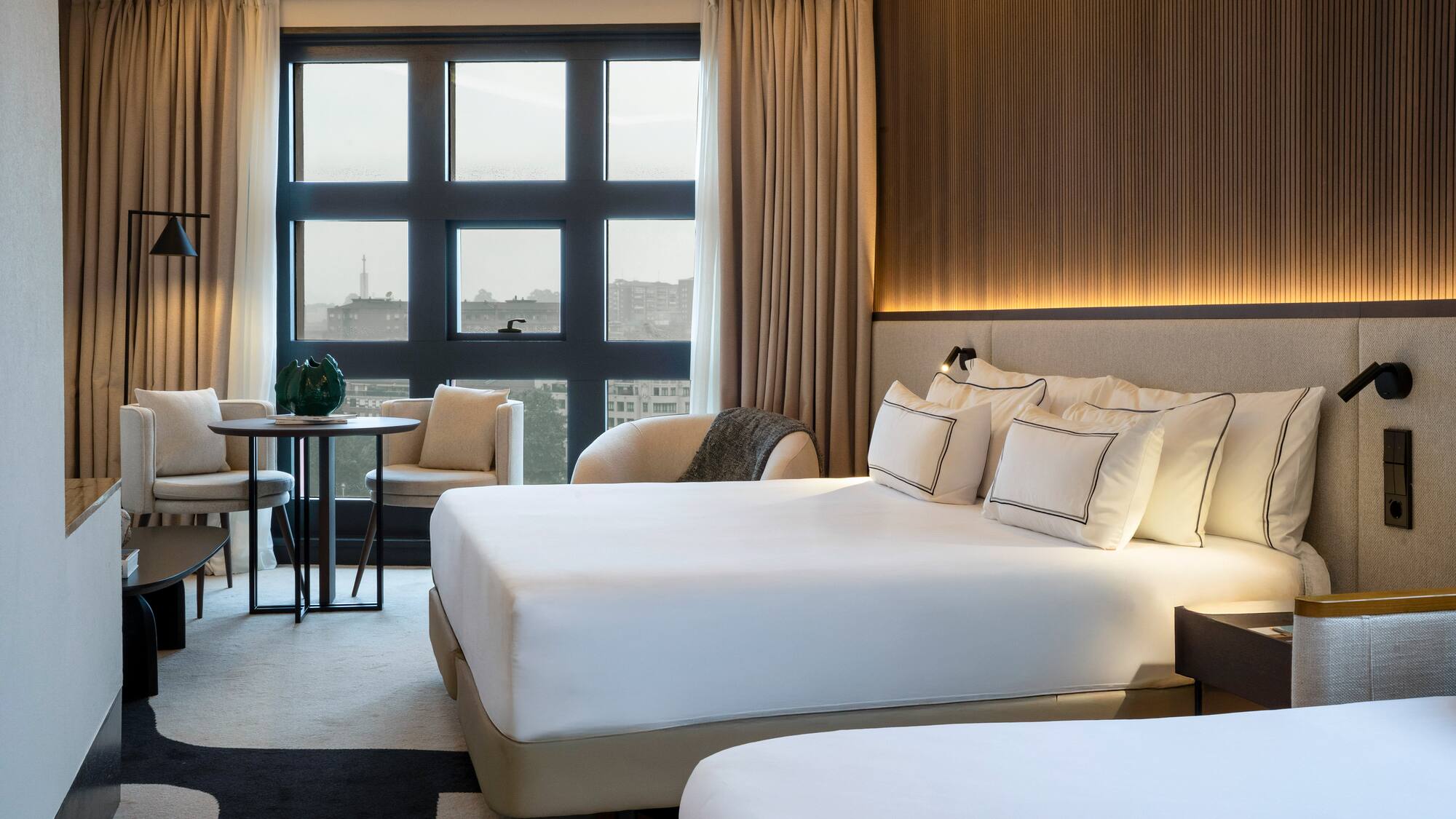 a room with a bed and chairs