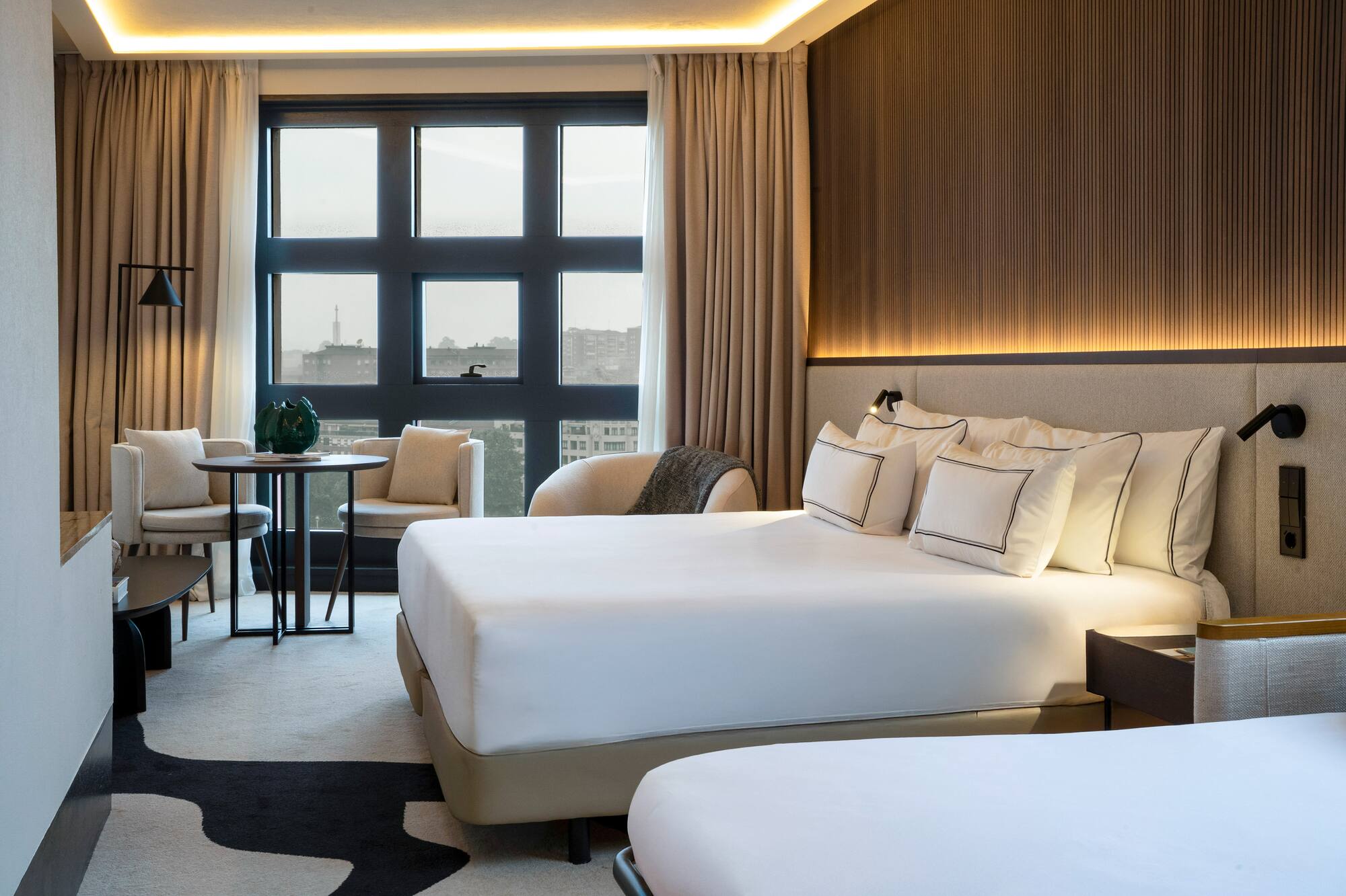 a room with a bed and chairs