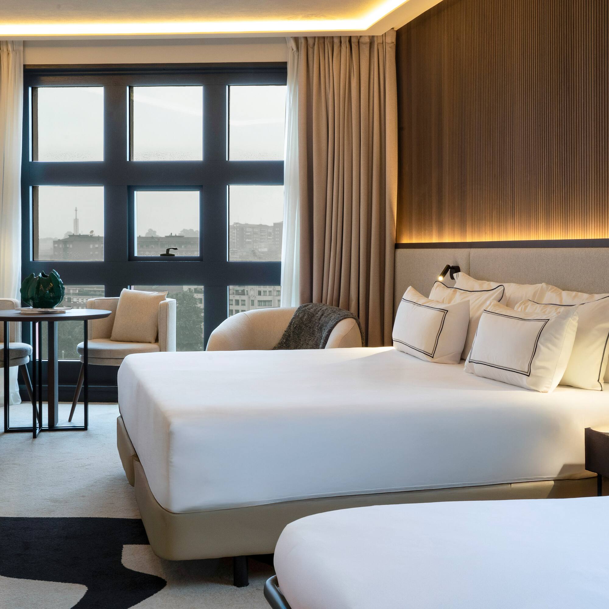 a room with a bed and chairs