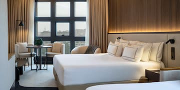 a room with a bed and chairs