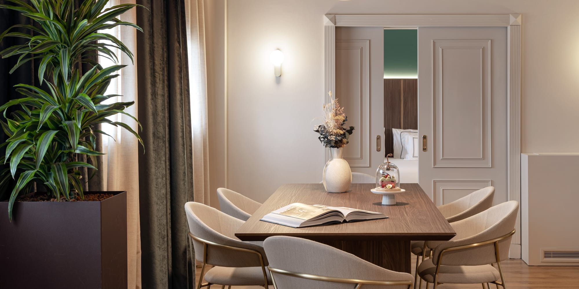 a dining table with chairs and a plant