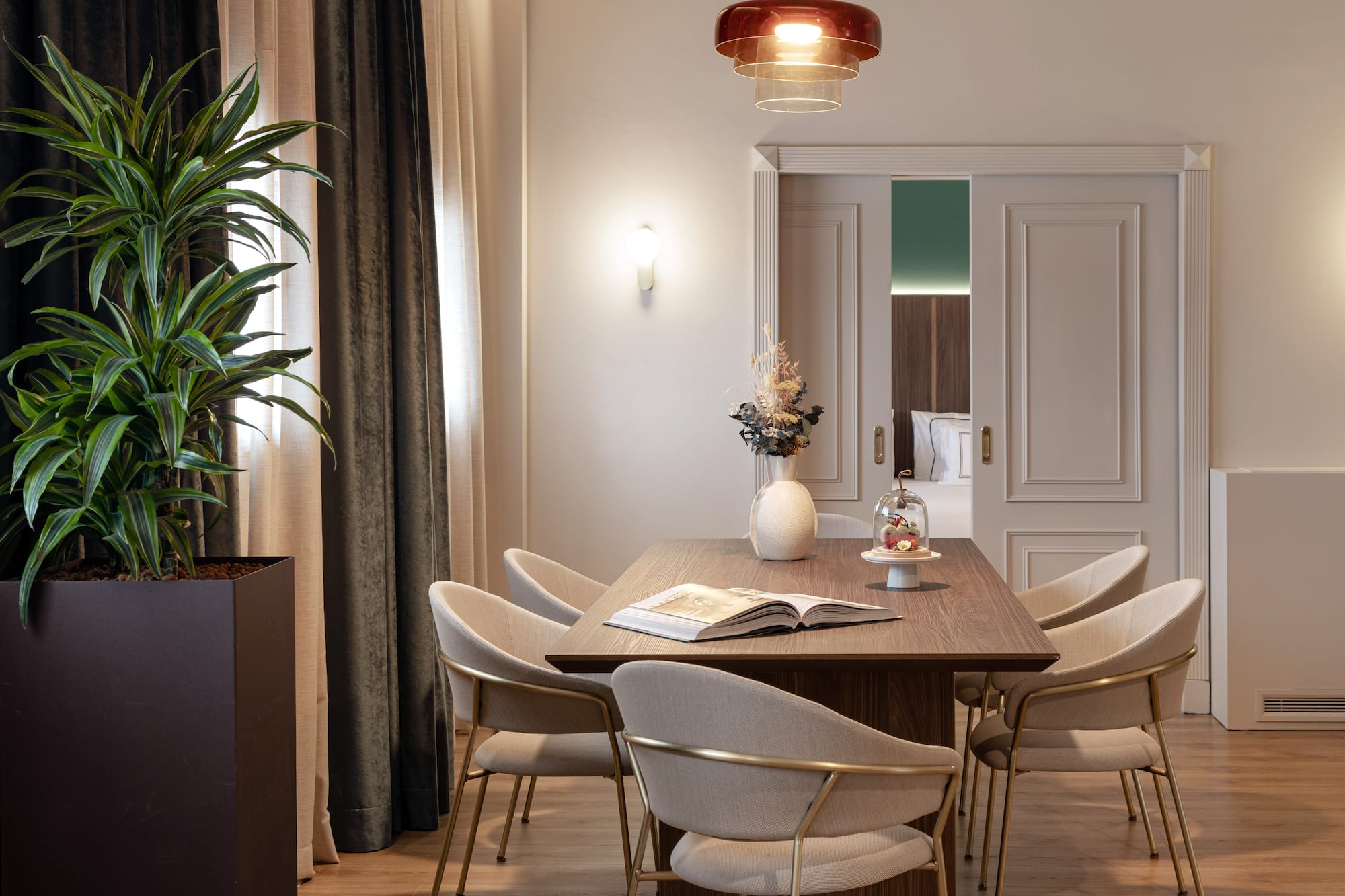 a dining table with chairs and a plant