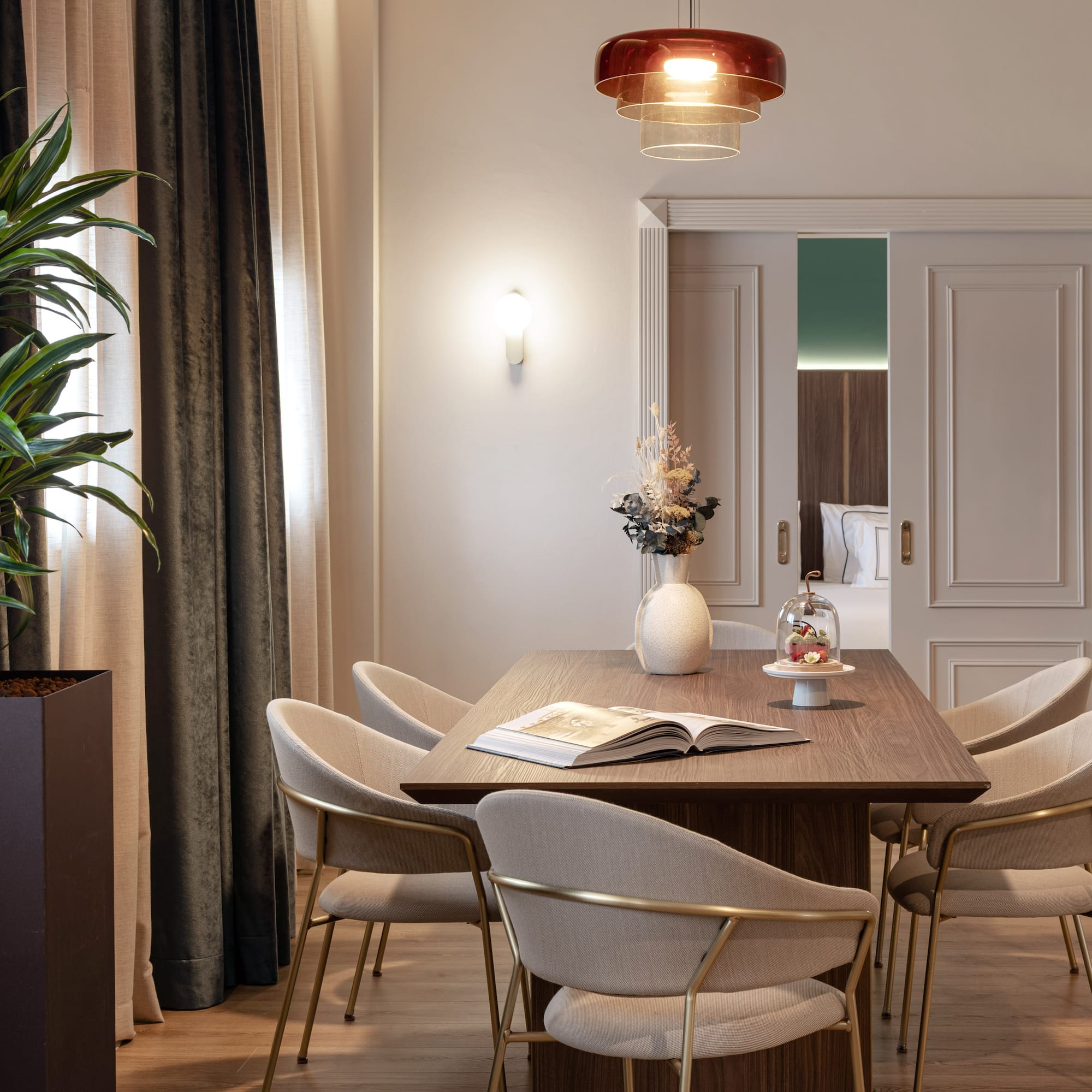 a dining table with chairs and a plant