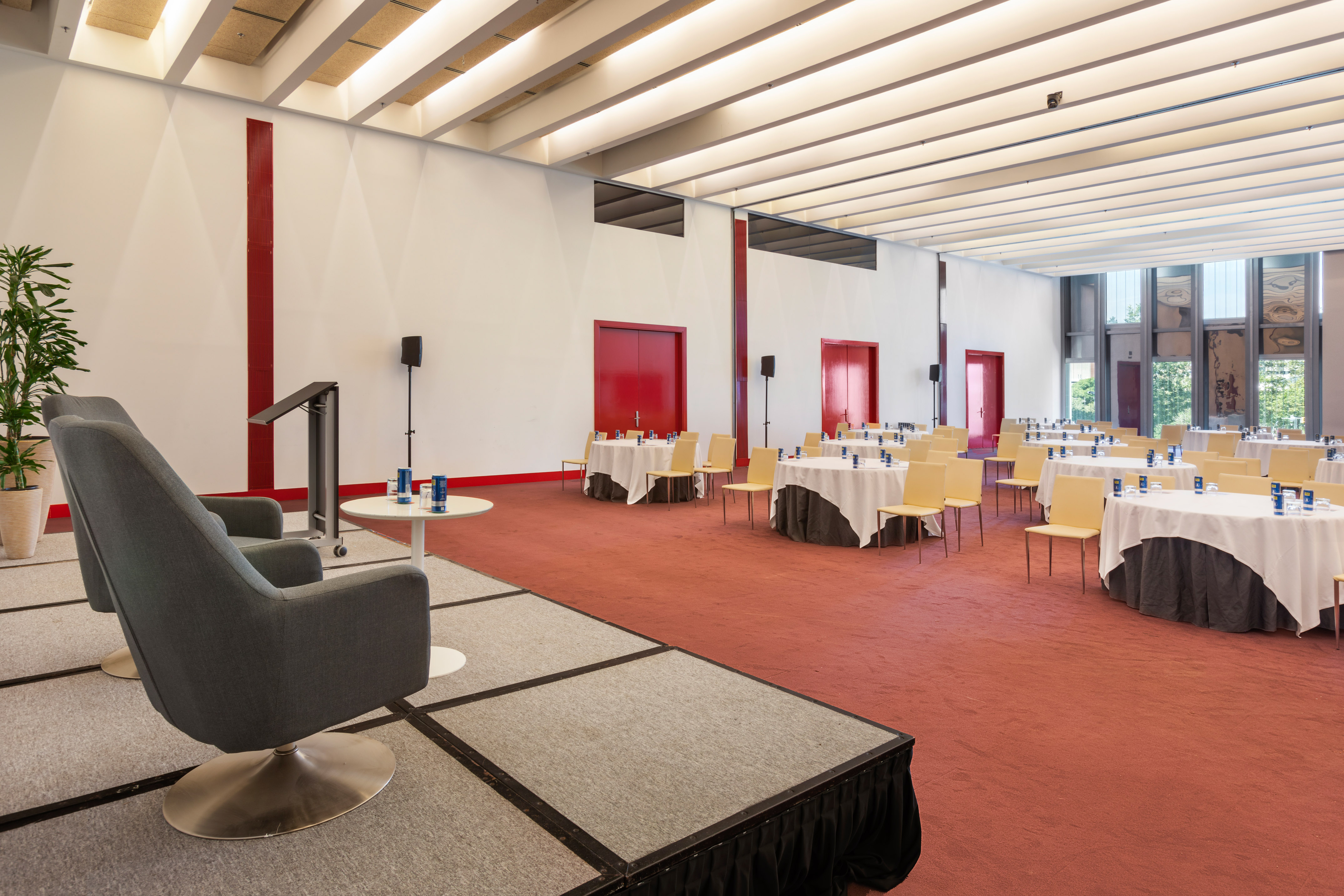 Empty modern conference room with red carpet, round tables, stage, and lectern. - Sky 1-2-3 - Meliá Barcelona Sky, Barcelona