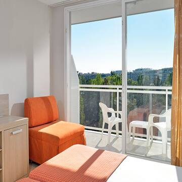 a room with a bed and chairs and a sliding glass door