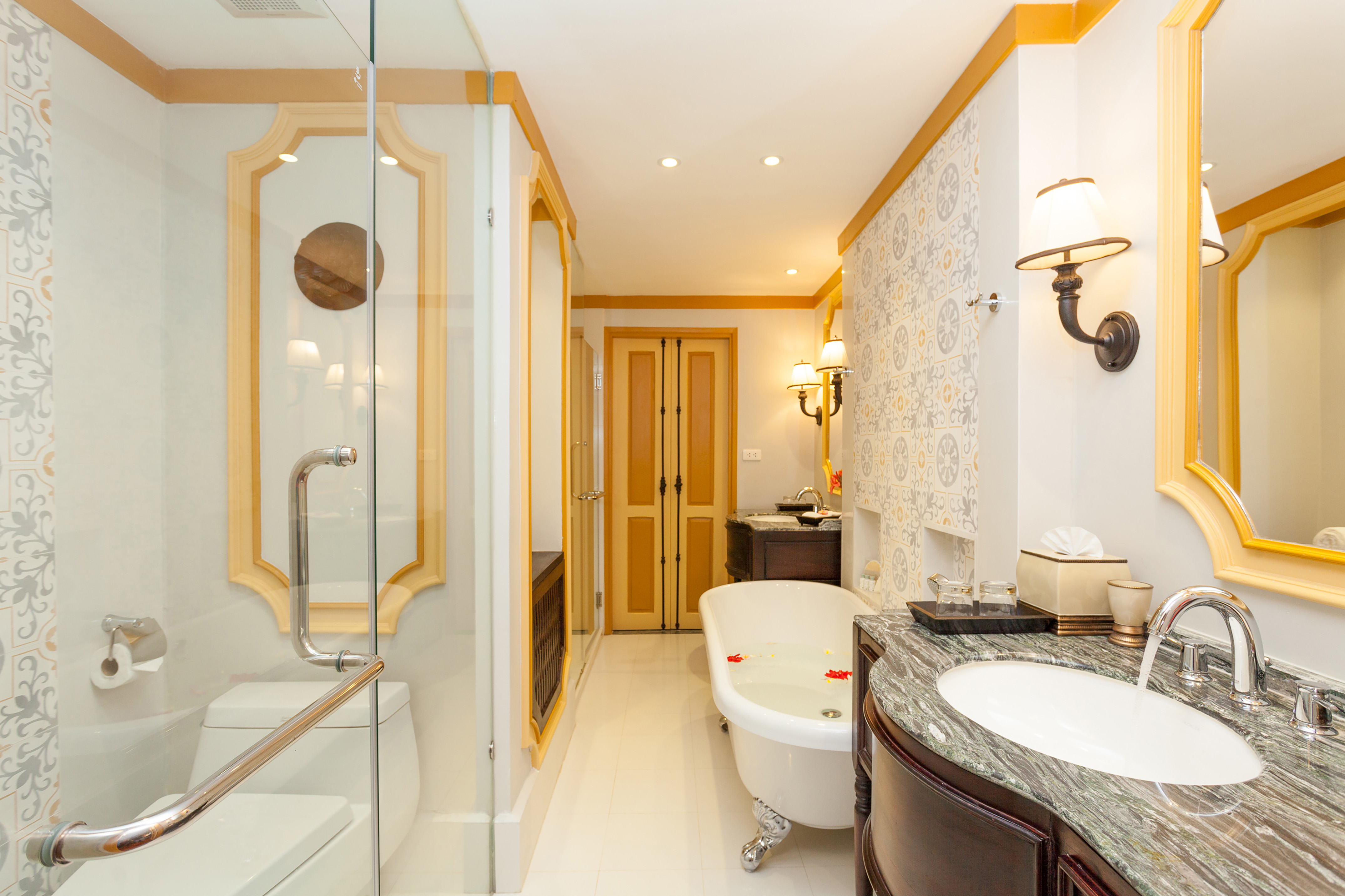 Elegant bathroom with clawfoot tub, glass shower, and marble vanity.