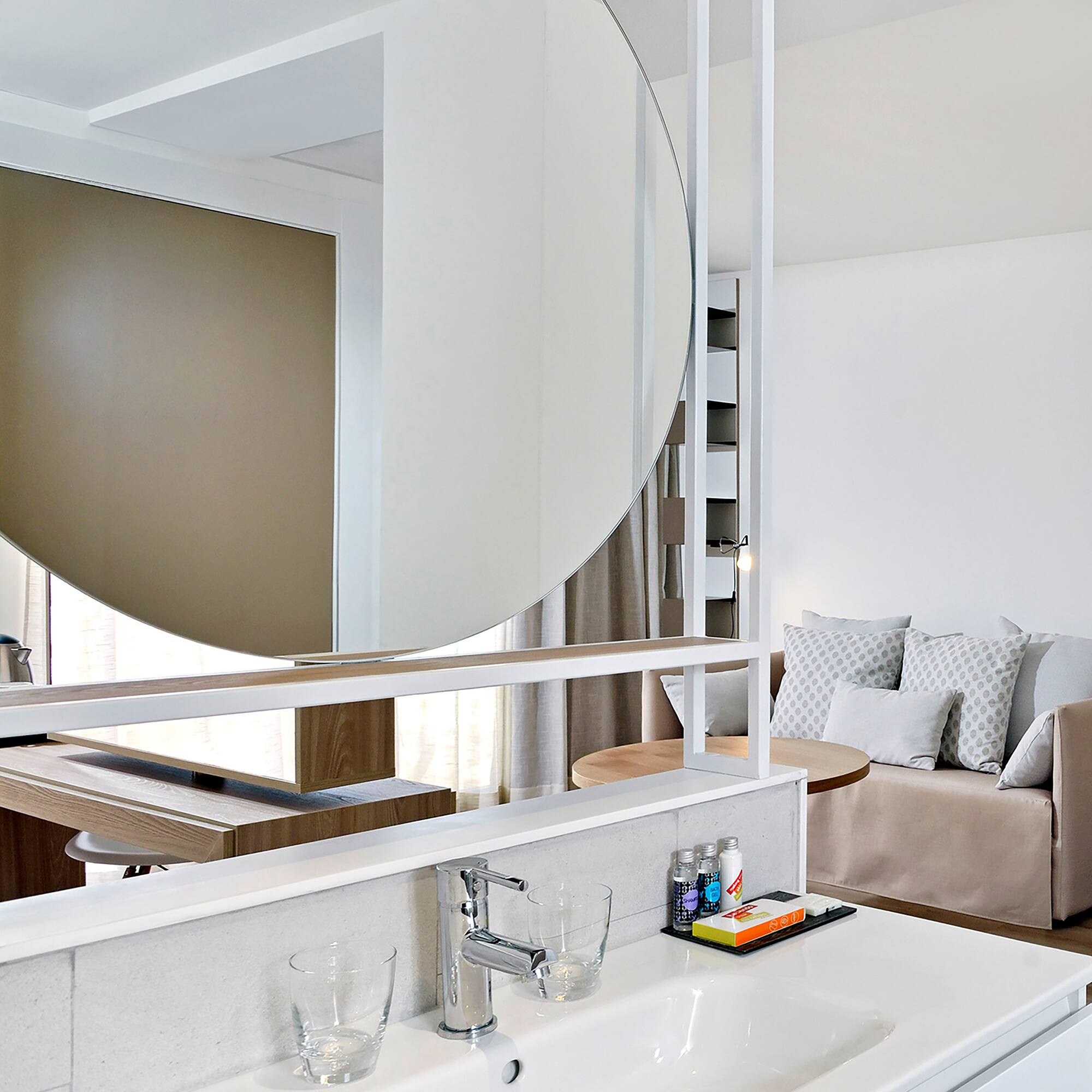 a bathroom with a large round mirror