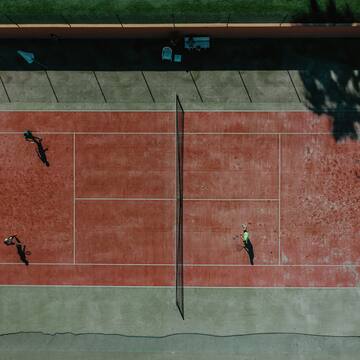 a tennis court with people playing tennis
