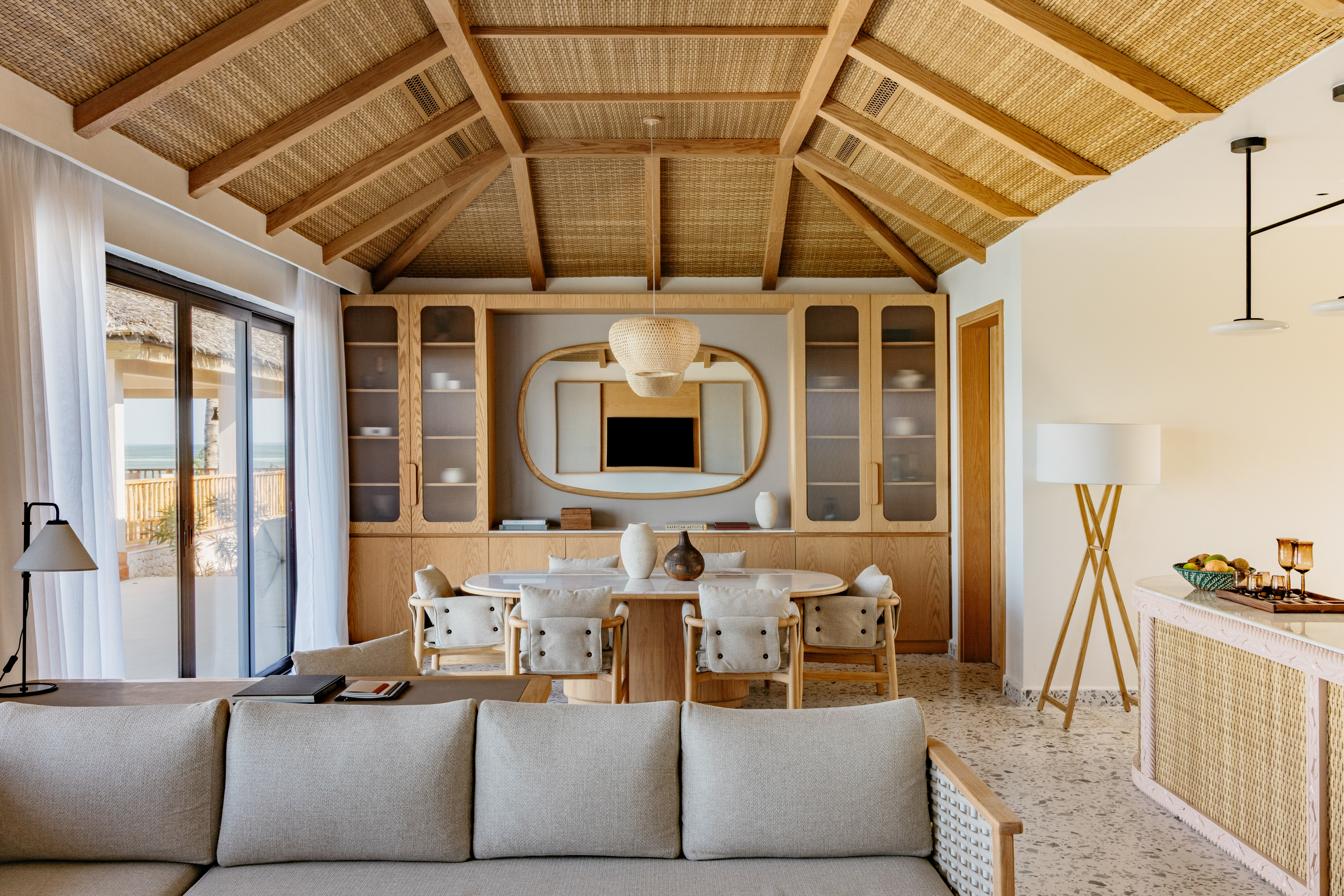 Luxury resort living and dining room with woven ceiling and ocean view.