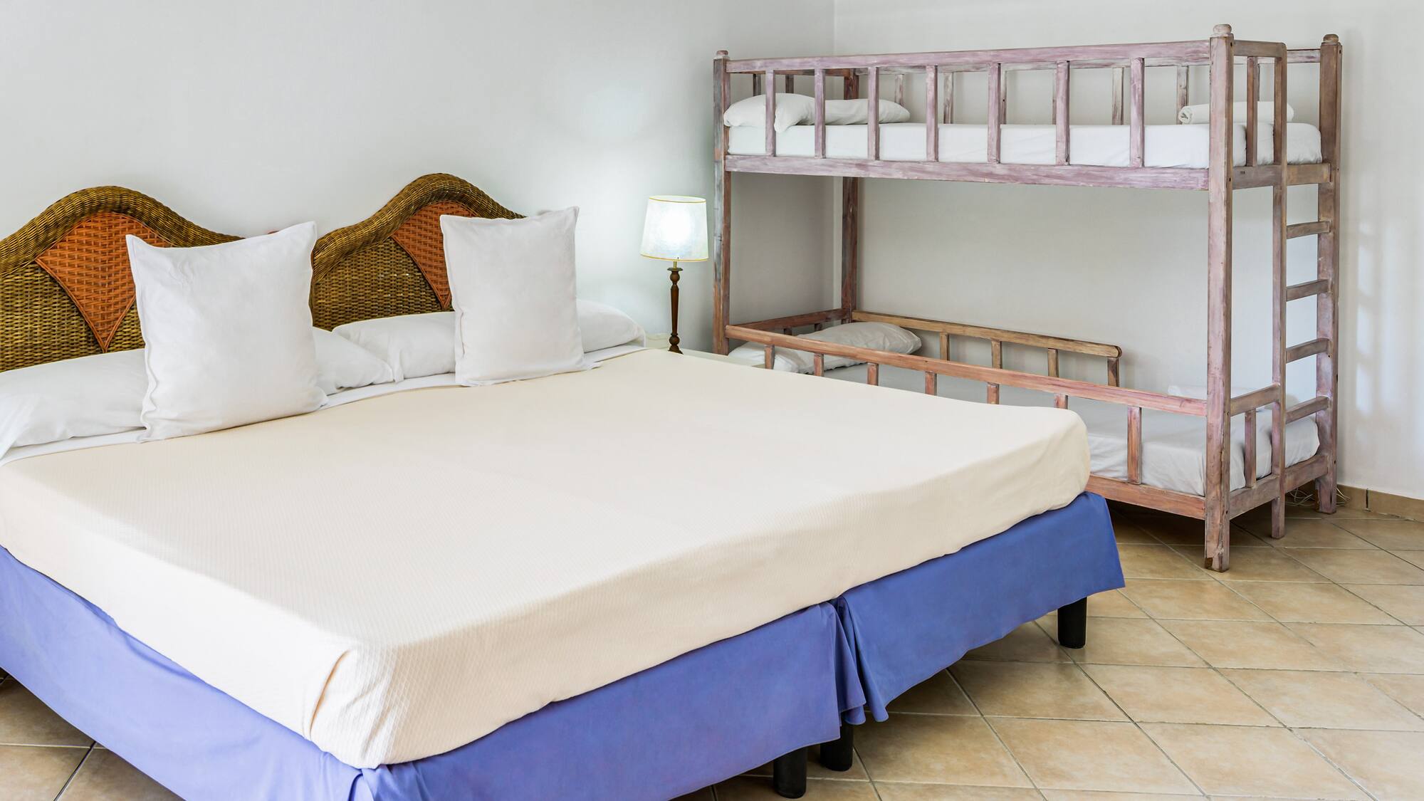 a bed with white pillows and a bunk bed