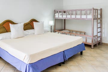 a bed with white pillows and a bunk bed