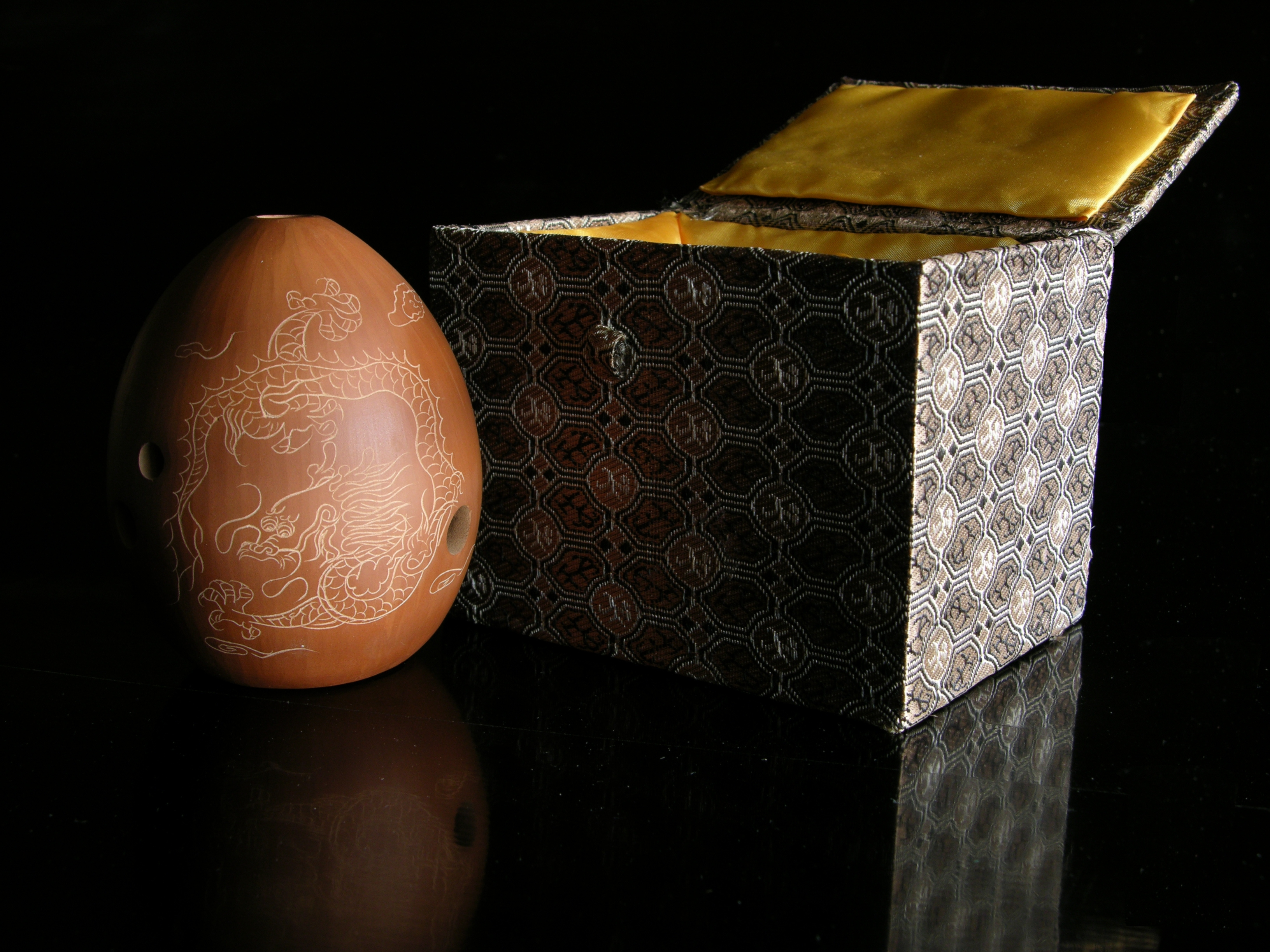a brown ceramic egg next to a box