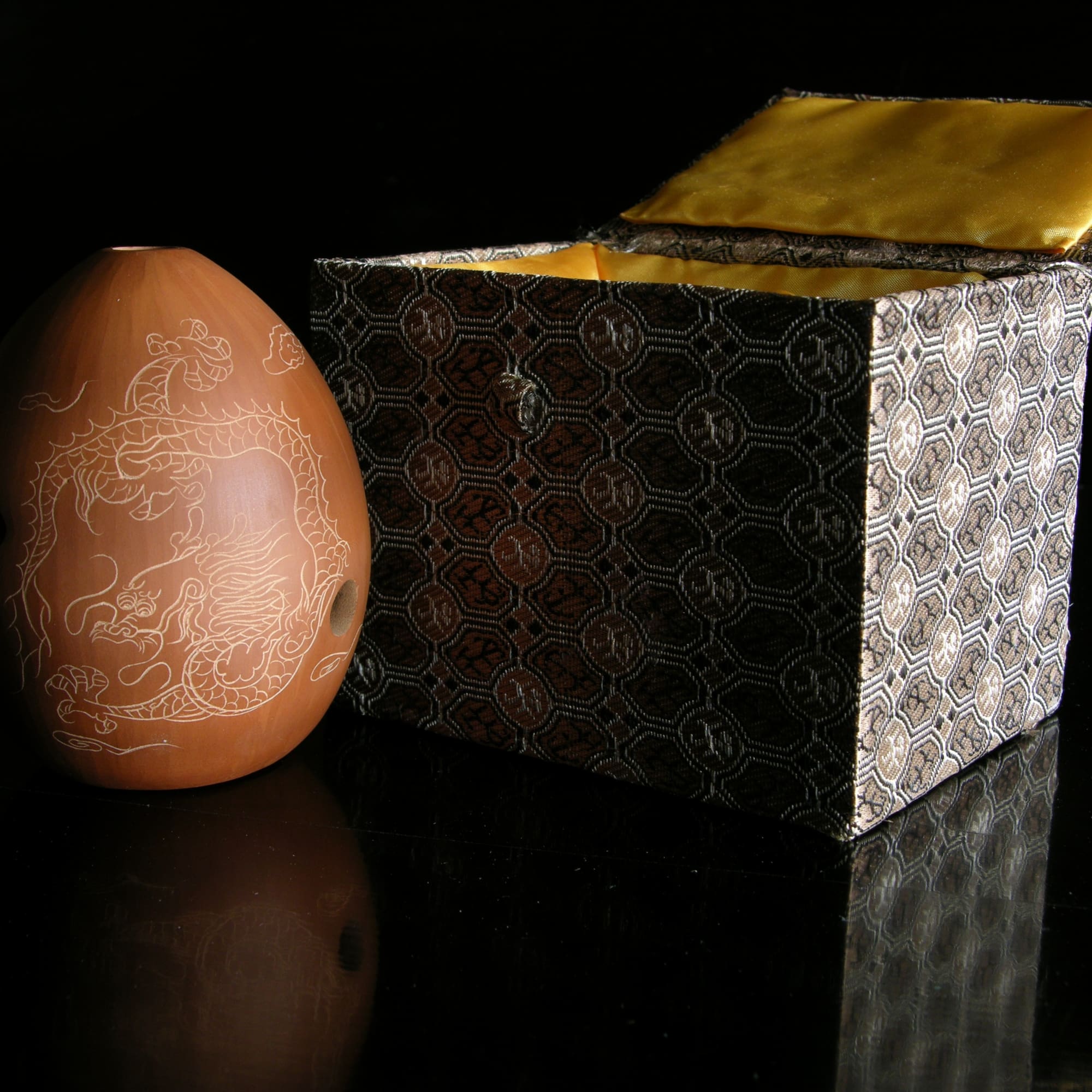 a brown ceramic egg next to a box