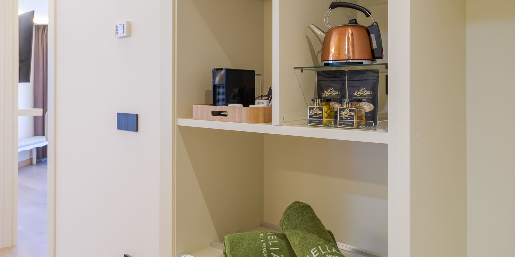 a shelf with towels and tea kettle