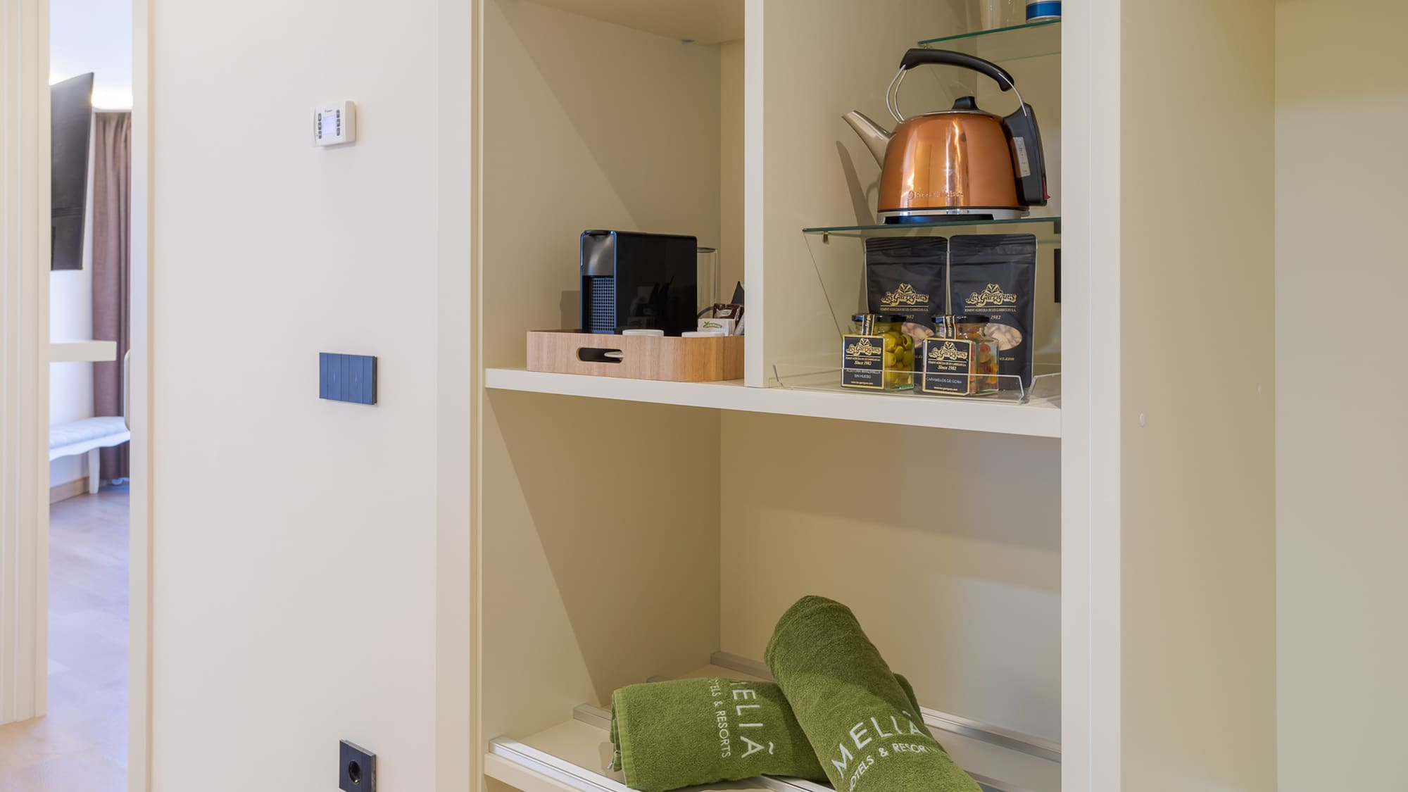 a shelf with towels and tea kettle