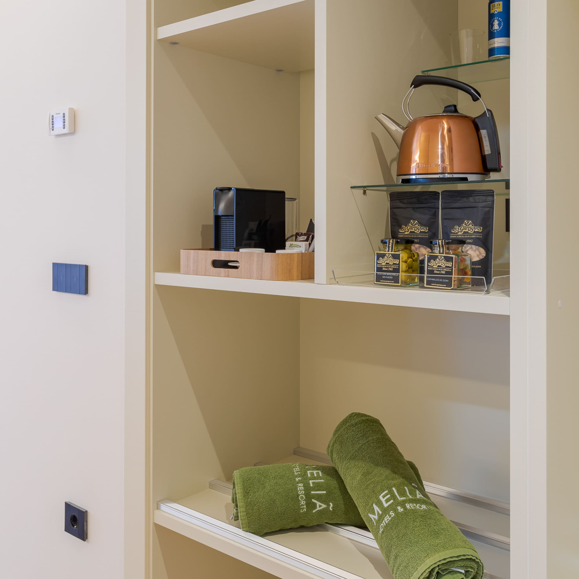a shelf with towels and tea kettle