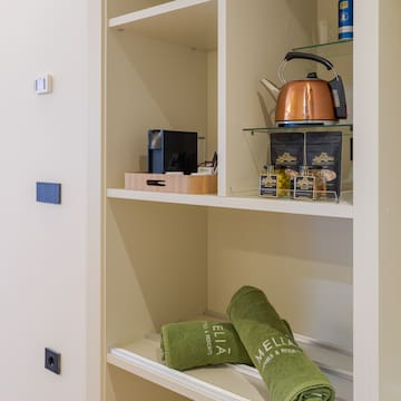 a shelf with towels and tea kettle