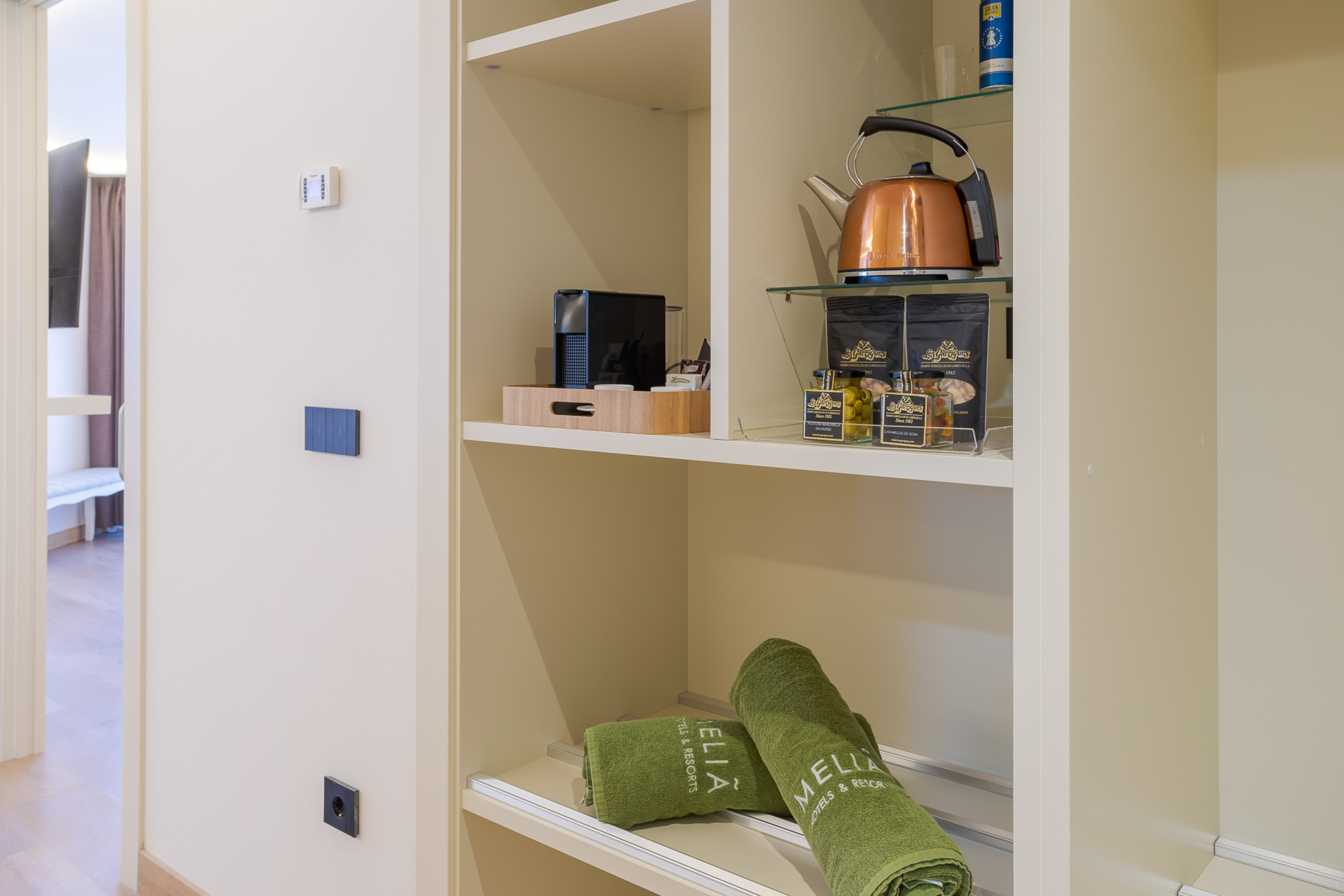 a shelf with towels and tea kettle