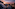 Rooftop terrace with igloo domes and city skyline under a vibrant sunset.