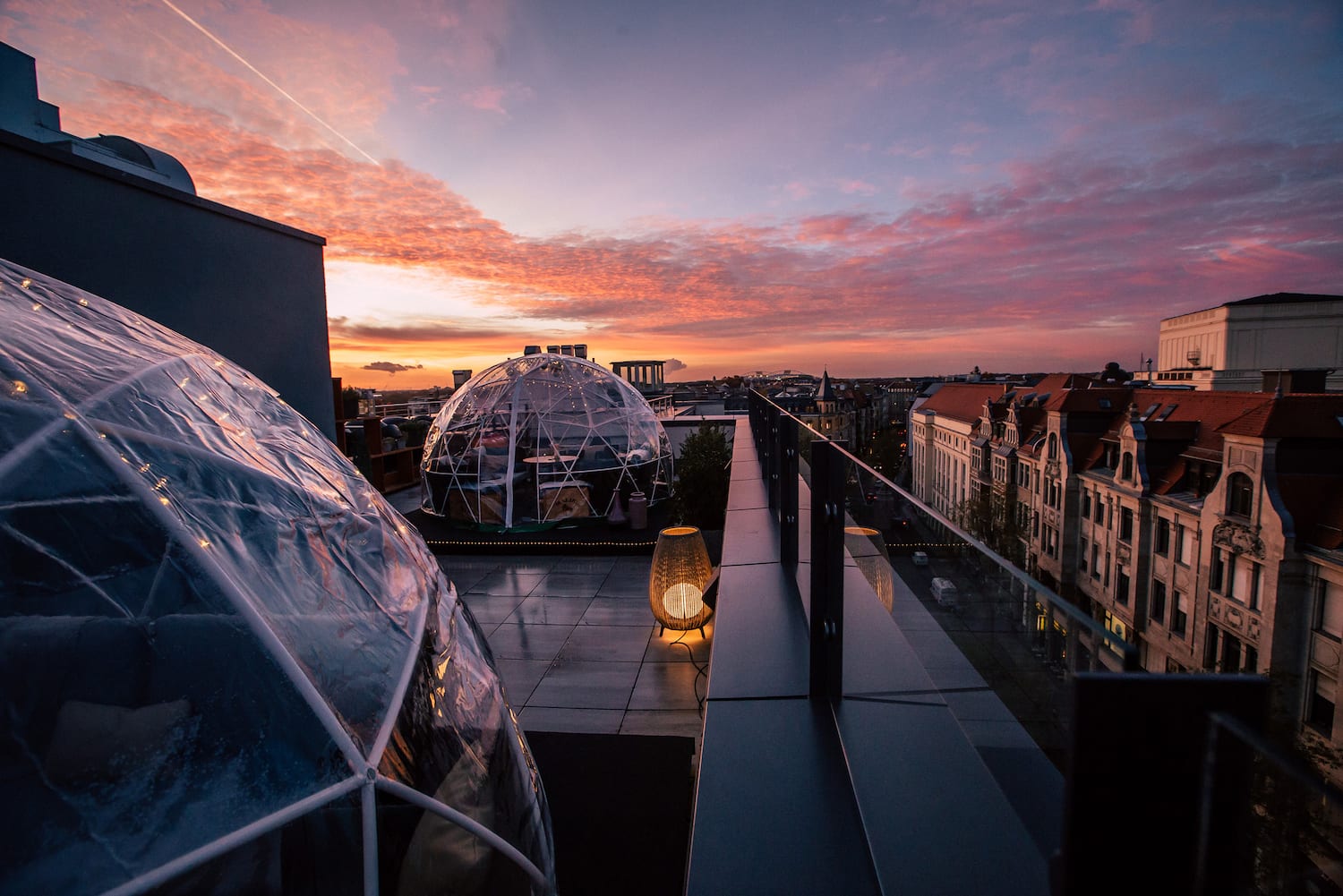 a rooftop with clear dome structures and a city in the background
