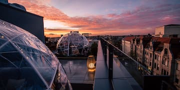 a rooftop with clear dome structures and a city in the background